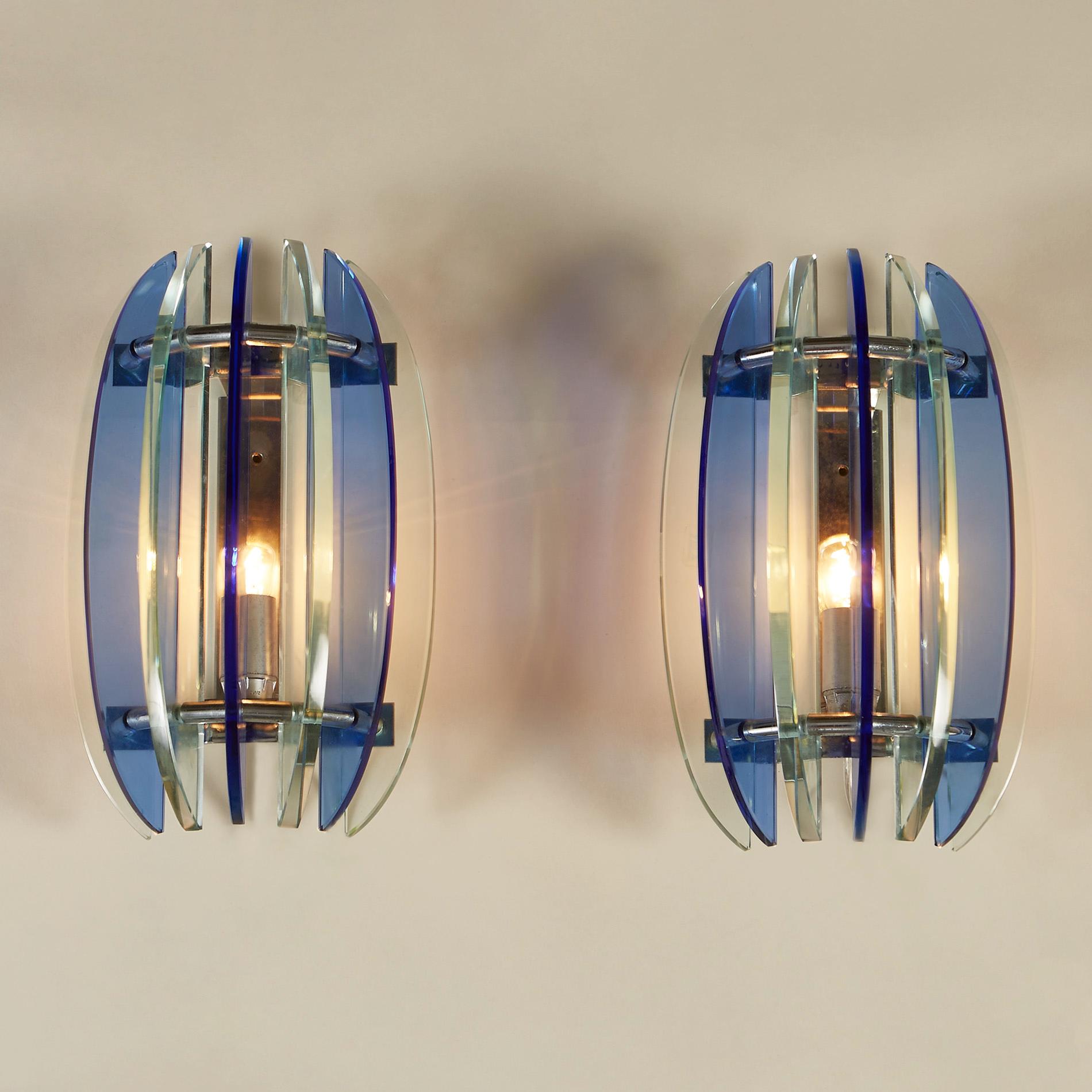 Pair of wall lights with alternating pale green and blue crystal glass pieces projecting out from chrome backplate.