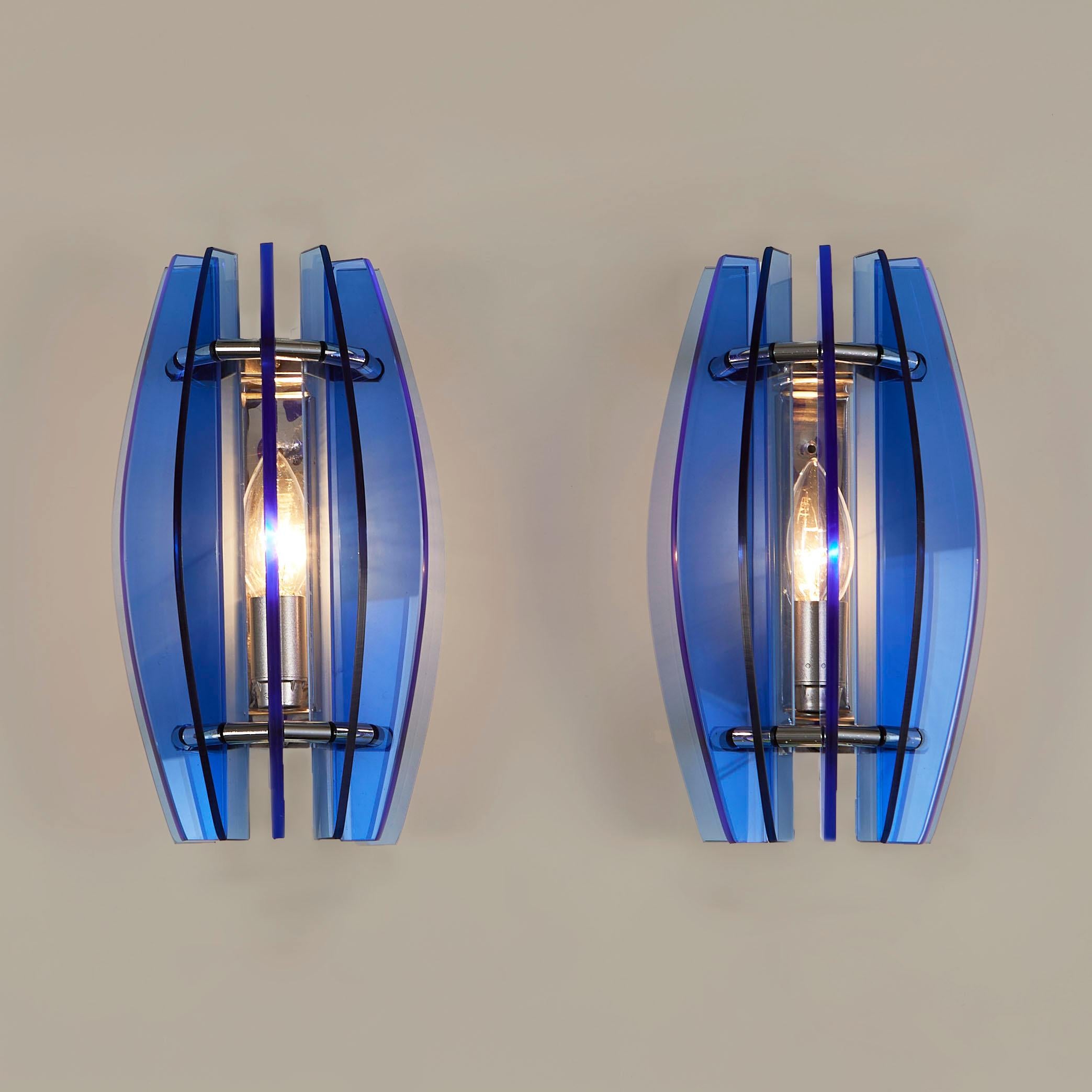 Leuchtend kobaltblaue, skulpturale Murano-Glasscheiben formen eine Kuppel über einer verchromten Rückwand.
