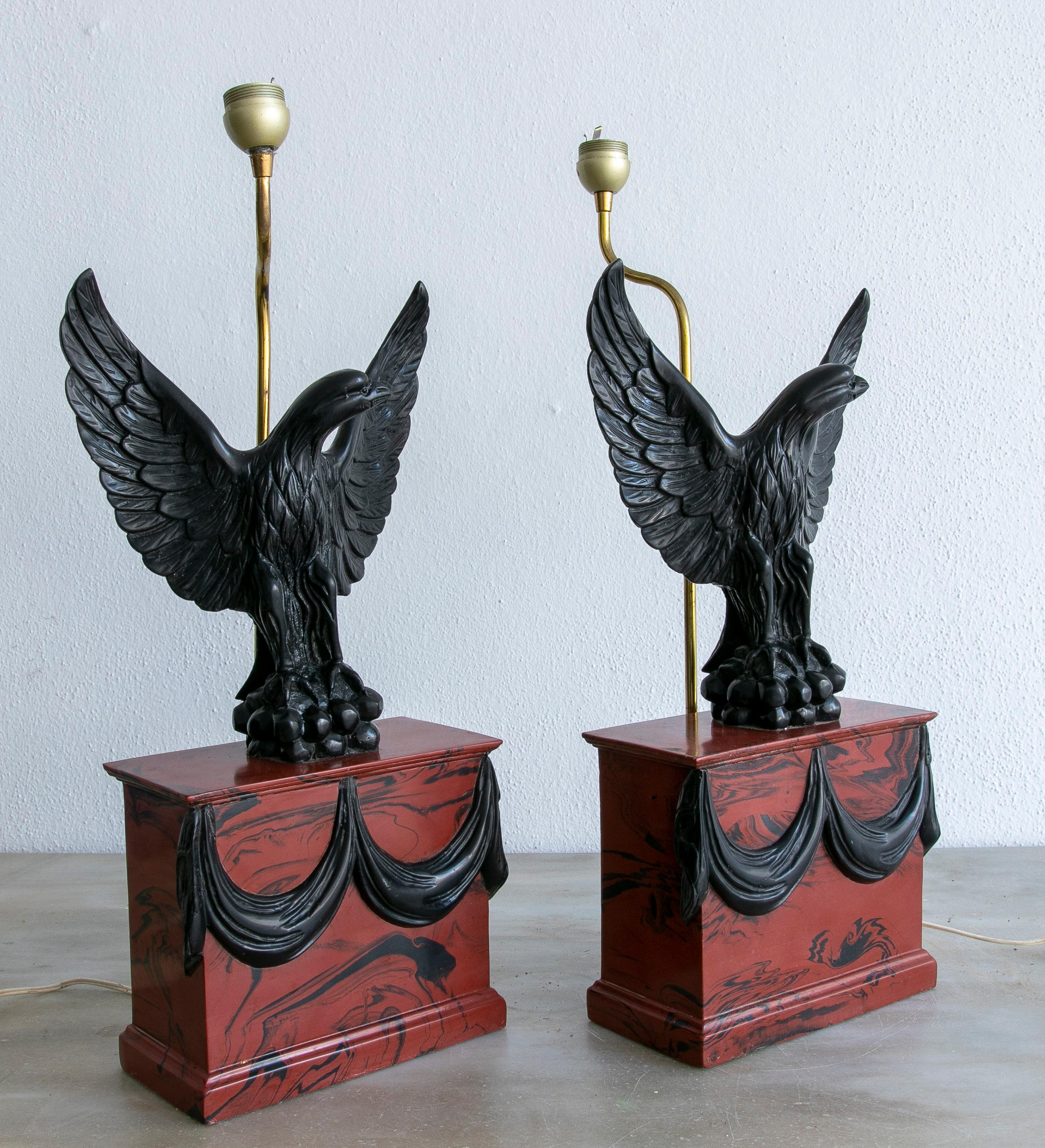 Pair of 1970s Italian faux marble resin table lamps with eagle figure sculptures.