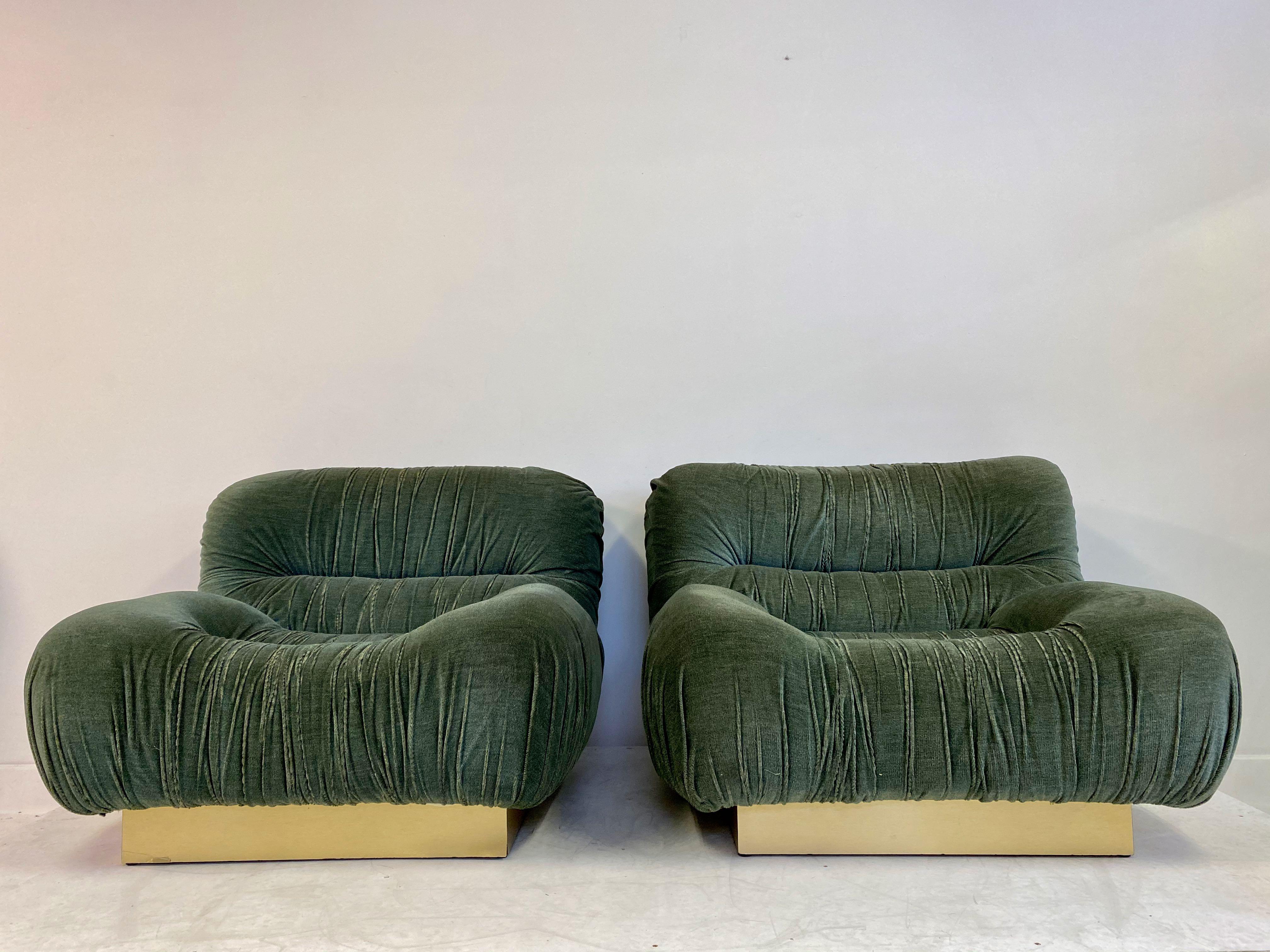 A pair of lounge chairs. 

Padded velvet.

Brass plinth,

1970s, Italian. 

Fabric is a little worn on the ruched edges. 

Measures: Seat height 37cm.