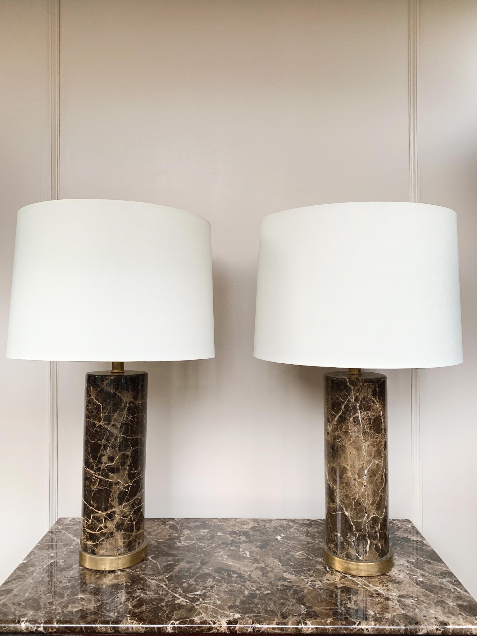 A pair of richly patterned marble lamps, made in the 1970s in Italy. They have cylindrical bodies with brass hardware. The lamps are newly rewired and paired with new custom-fitted linen shades.

Dimensions:
27 in. height
5.5 in. base