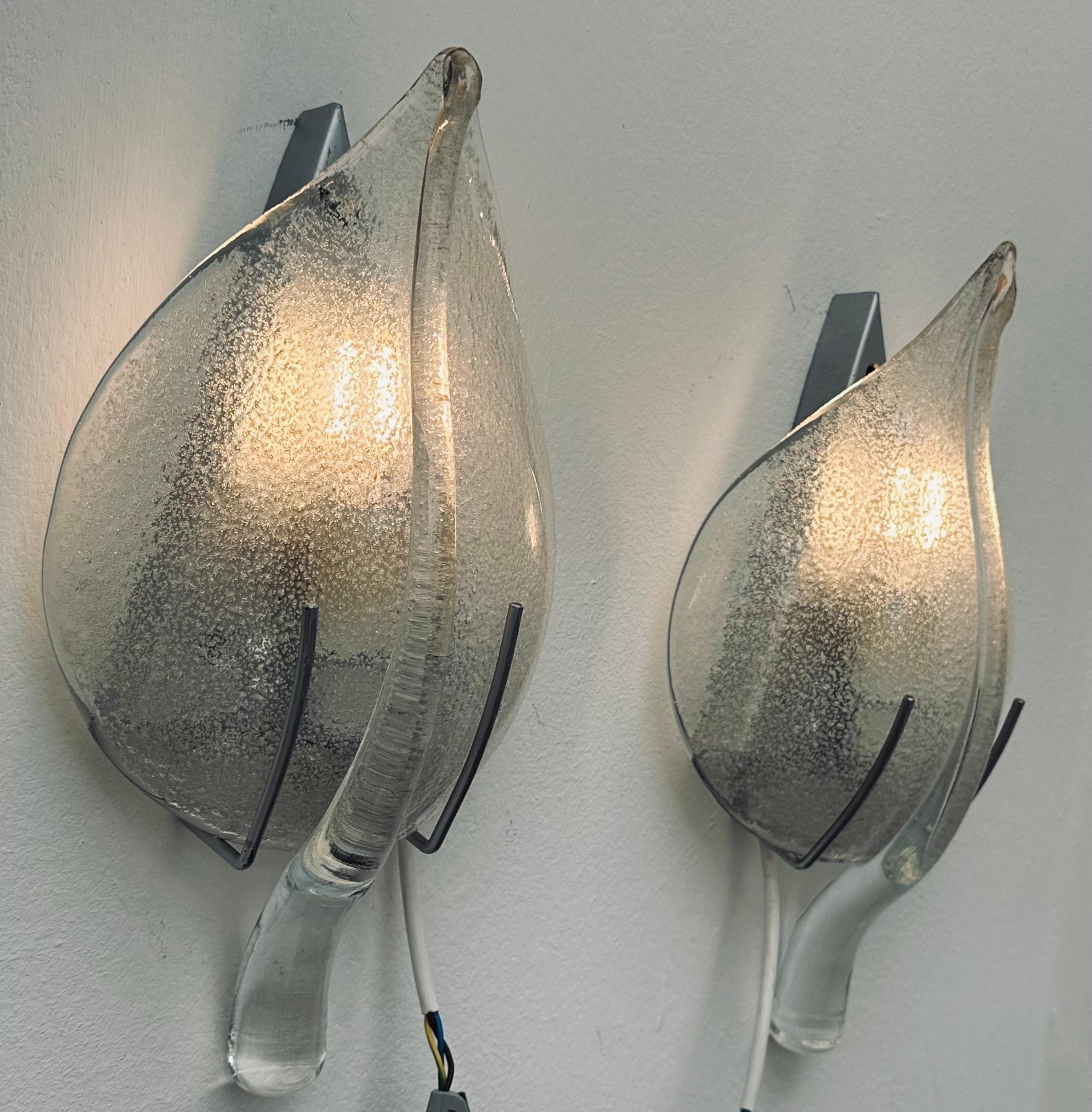 Pair of 1970s vintage Italian Murano glass wall sconces or lights in the style of Franco Luce or Sölken Leuchten. The transparent mottled leaf has a protruding vein running down the centre and a stem at the bottom which holds it in place. The glass