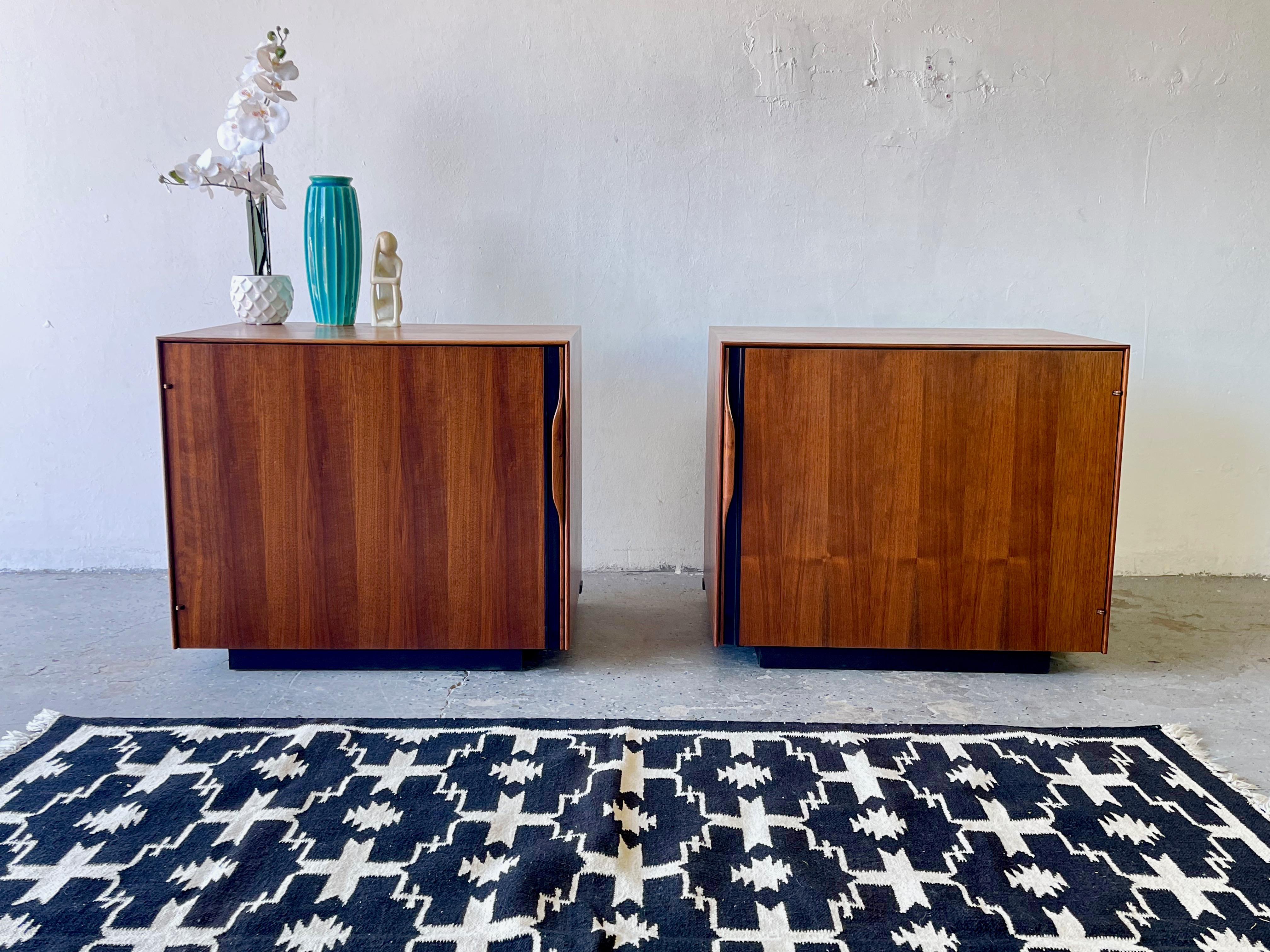 A pair of Glenn of California end tables / bar tables by John Kapel. Walnut with sculpted wood handles, and black floating bases. Both have adjustable interior shelves

In excellent condition. Dimensions: 28