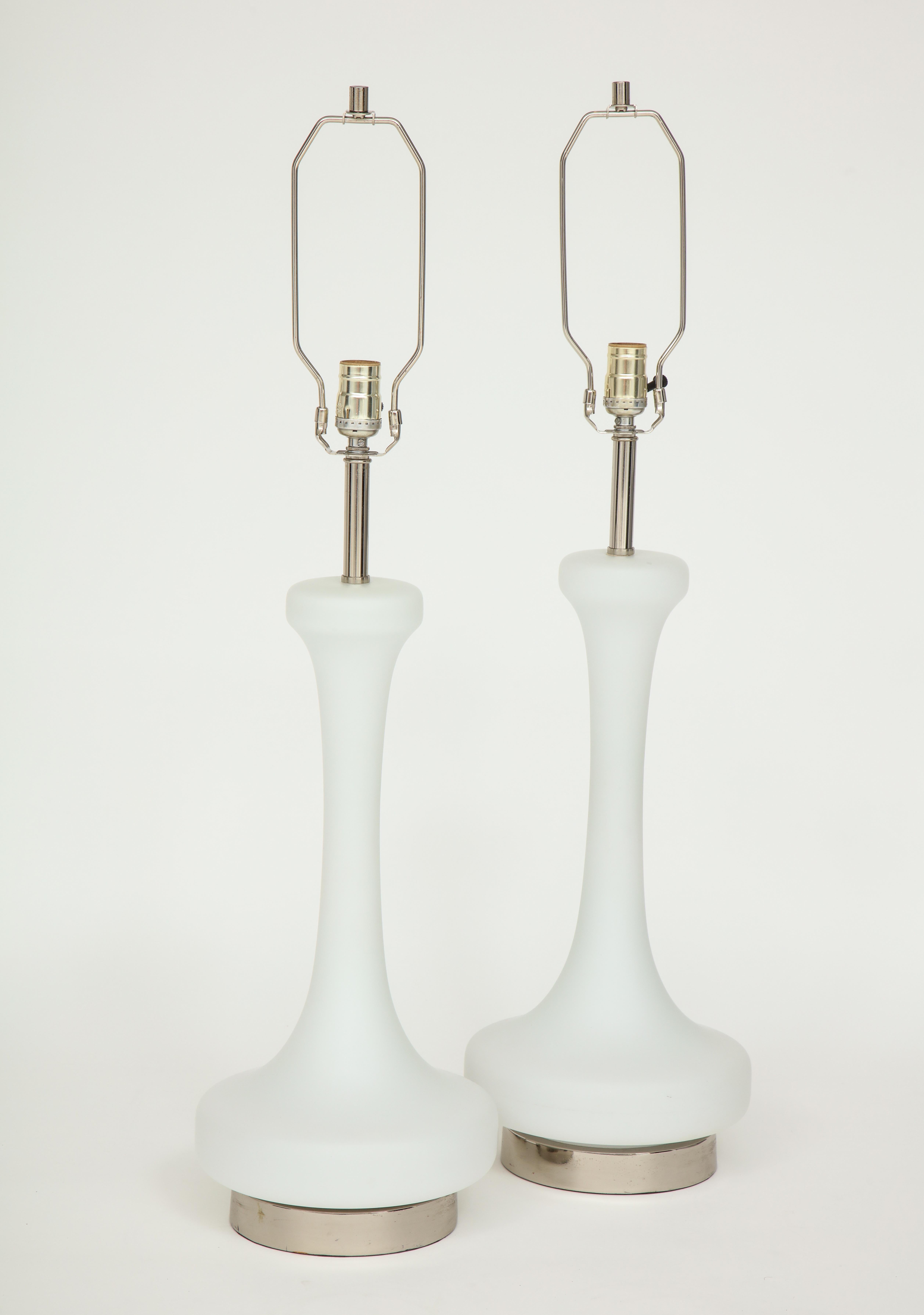 Pair of 1970s midcentury lamps by Laurel Lighting company.
The white frosted lamp bodies are mounted on polished chrome bases which can be illuminated by a 3- way switch. They have been newly rewired for the US and take standard light bulbs.
The
