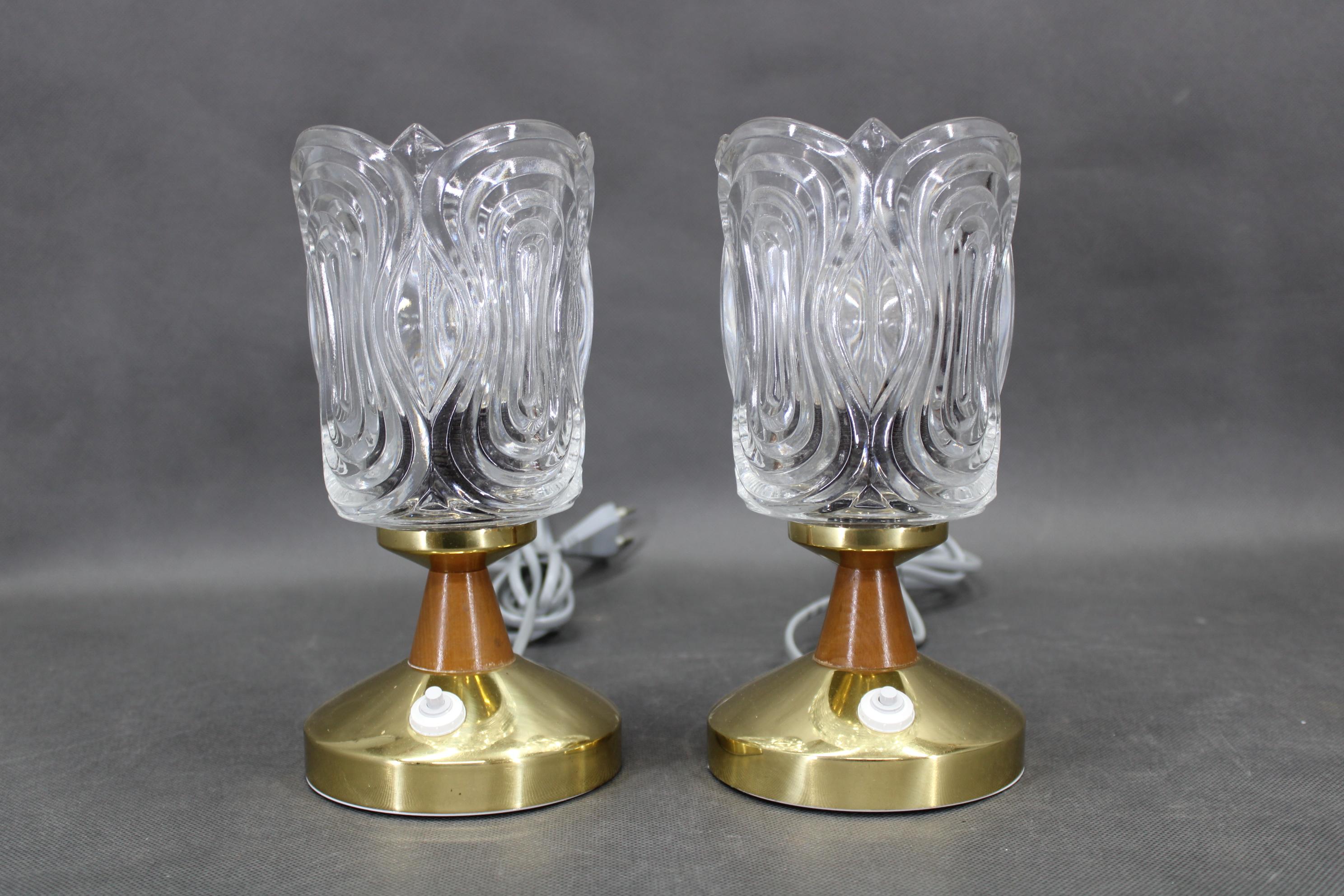Un par de lámparas de mesa vintage de mediados de siglo fabricadas por Lidokov en la Checoslovaquia de los años setenta. Estas lámparas presentan tulipas gruesas de vidrio prensado con un relieve escultórico ornamentado que crea una cautivadora