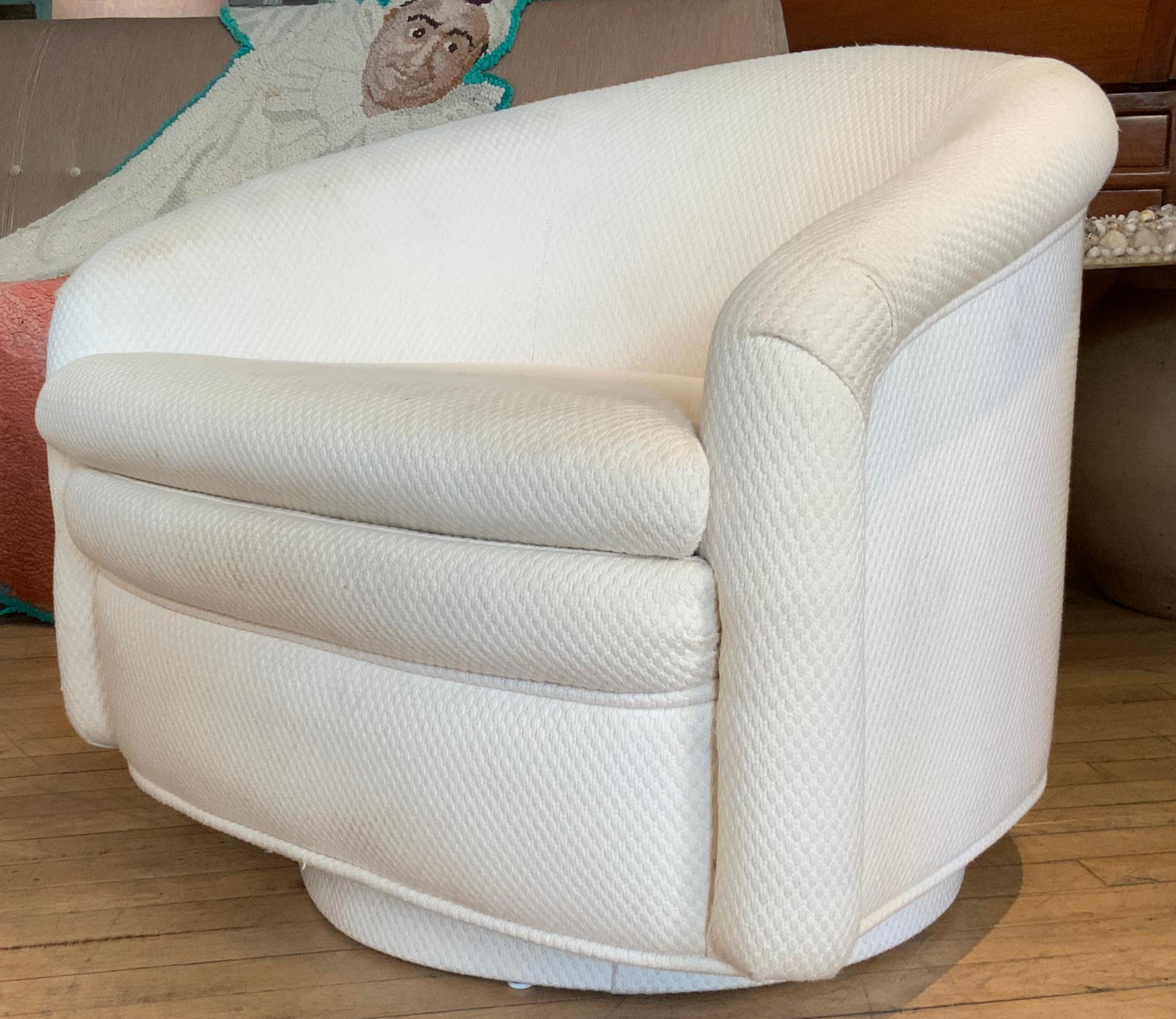 A pair of very stylish 1970s modern swivel lounge chairs, with beautiful scale and proportions. with barrel backs, and upholstered bases. very comfortable, in their original white upholstery, which show age expected wear and some marks.