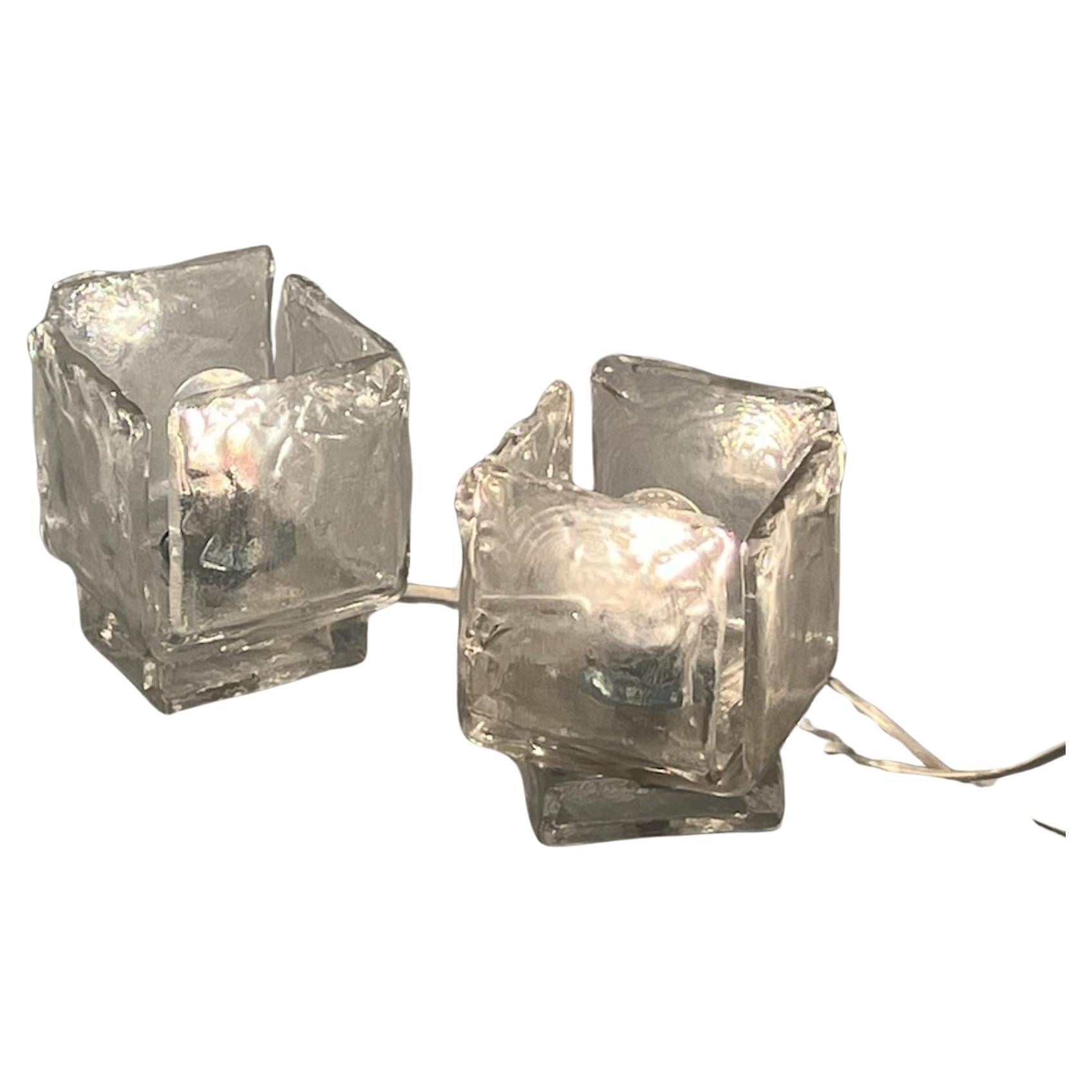 Exclusive pair of 1970s Murano Glass Lamps, meticulously crafted to perfection by historic Vetrerie Toso in Italy.

Imbued with the enchanting allure of ice-like Murano glass, these lamps are not just lighting fixtures; they are captivating works of