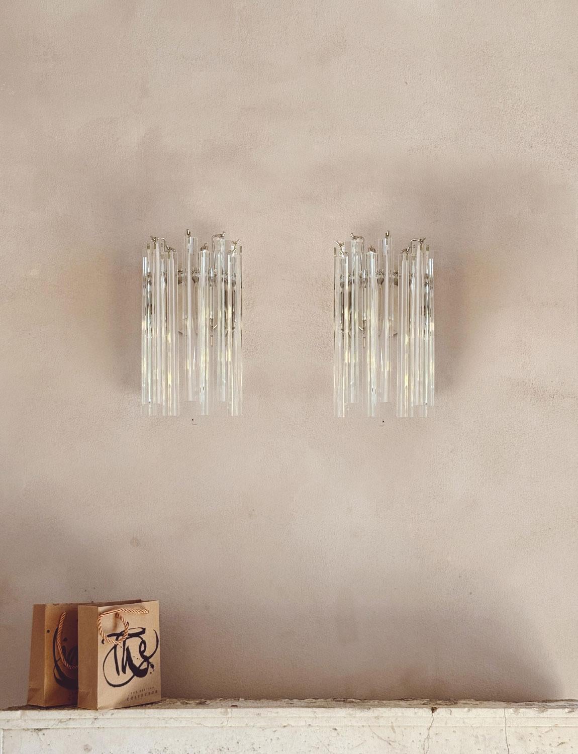 Luci da parete in vetro di Murano trasparente di grande eleganza. Ogni pezzo di vetro di Murano (nove in totale) è appeso a una struttura metallica e l'apparecchio di illuminazione è posizionato in modo ordinato dietro. In buone condizioni di