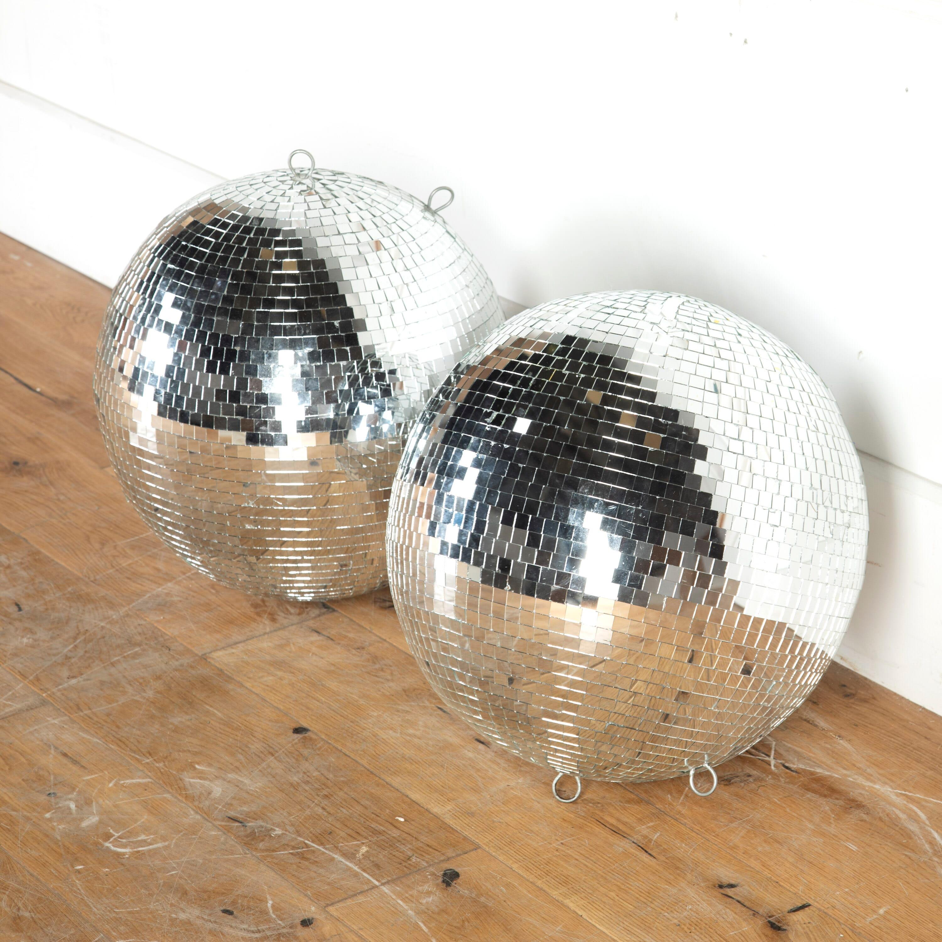 Funky pair of original 1970s nightclub mirrored disco balls. 

These disco balls will evoke all the fun of the 70s in an interior and have a wonderful reflective quality. 

They are in a fair condition commensurate with their age; no losses, but