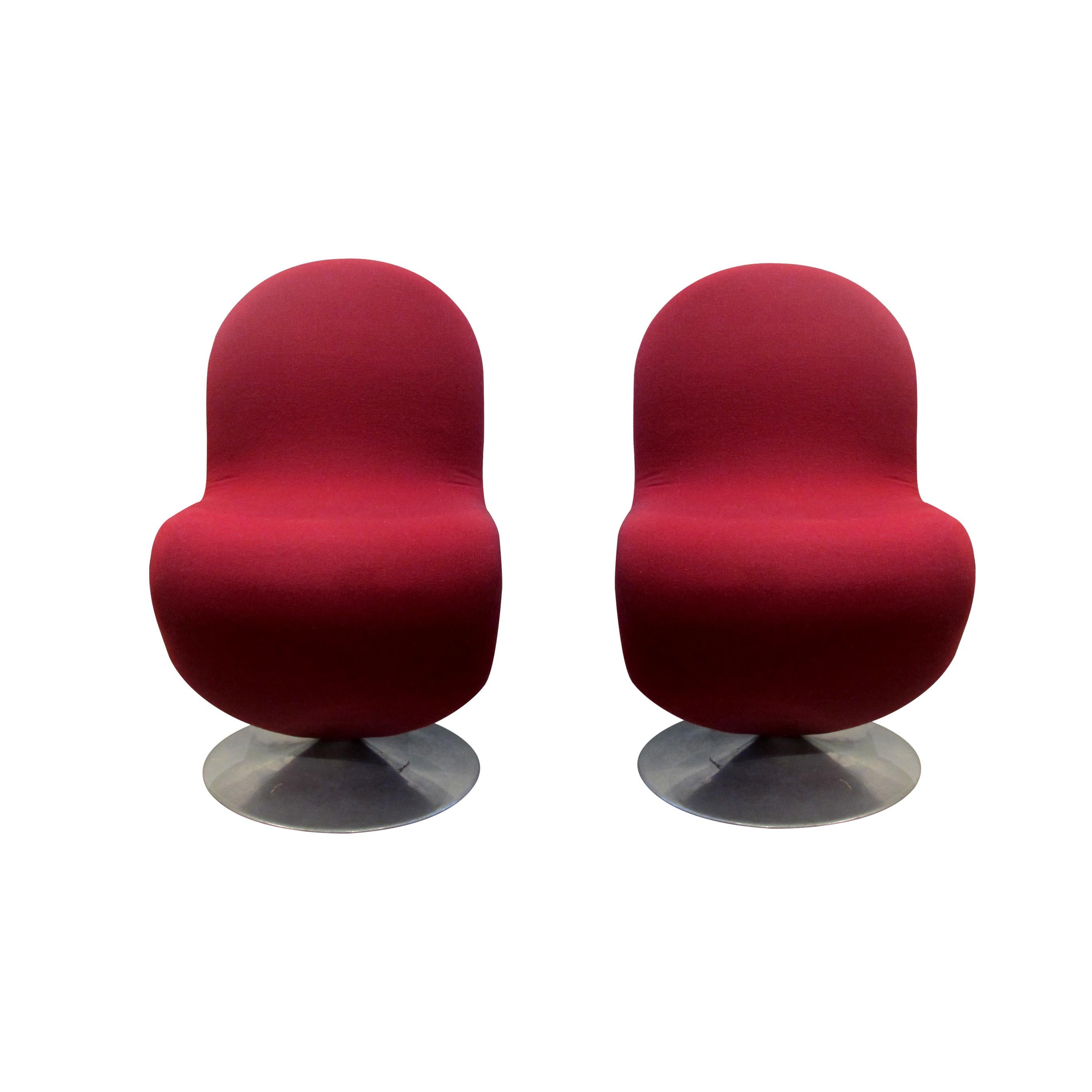 A pair of original 1970s iconic cantilever Verner Panton 1-2-3 Series swivel dining chairs with a brushed steel base. The chairs are upholstered in a red wool fabric with some minor signs of wear on the base. The tight fit sleeves are held on the