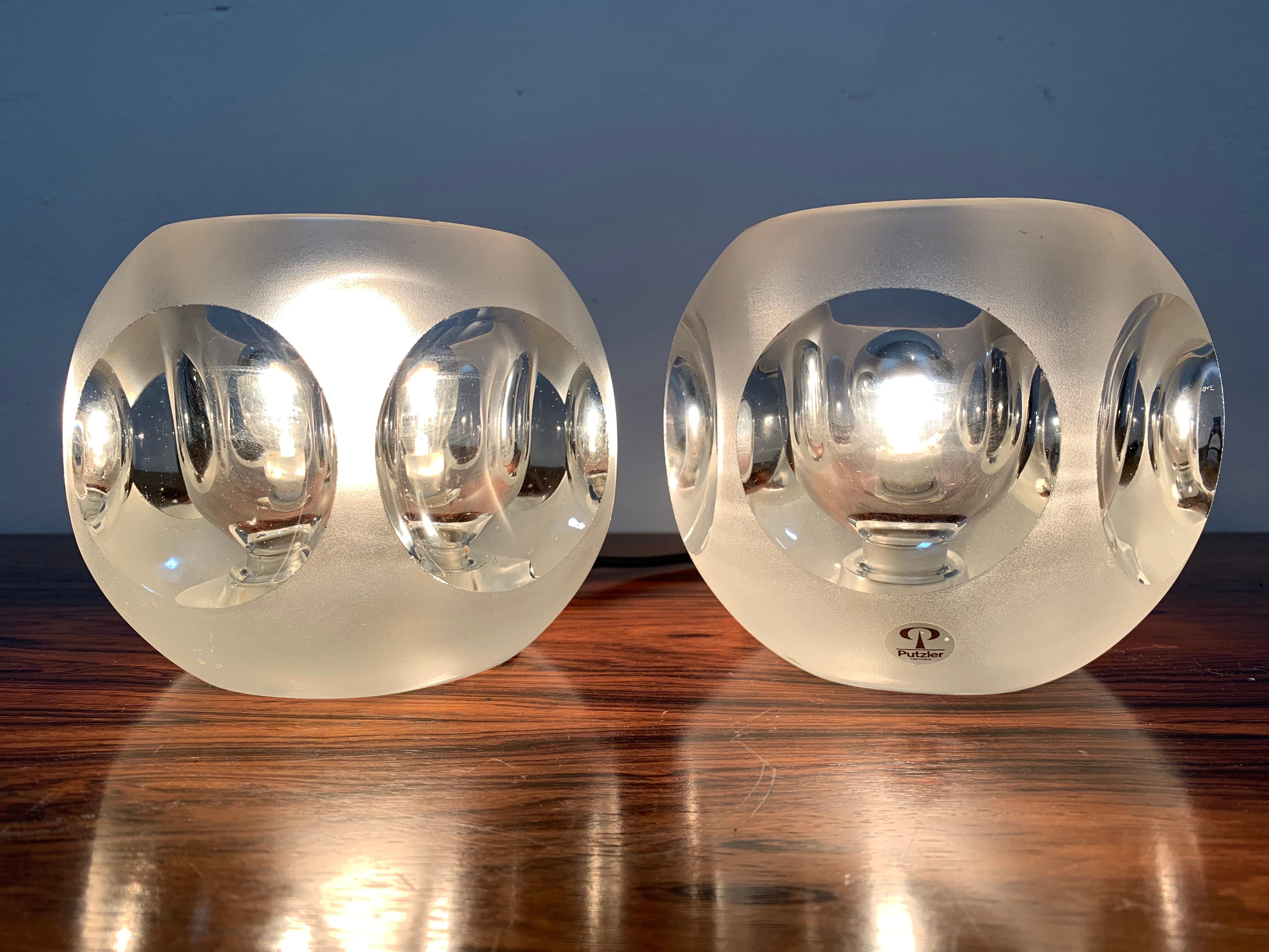 Pair of 1970s Peill and Putzler frosted and clear glass round ice cube table lights. The lights have four convex indentations which magnifying and reflect the light. An on/off switch sits on the black flex. One light still feature the manufacturers