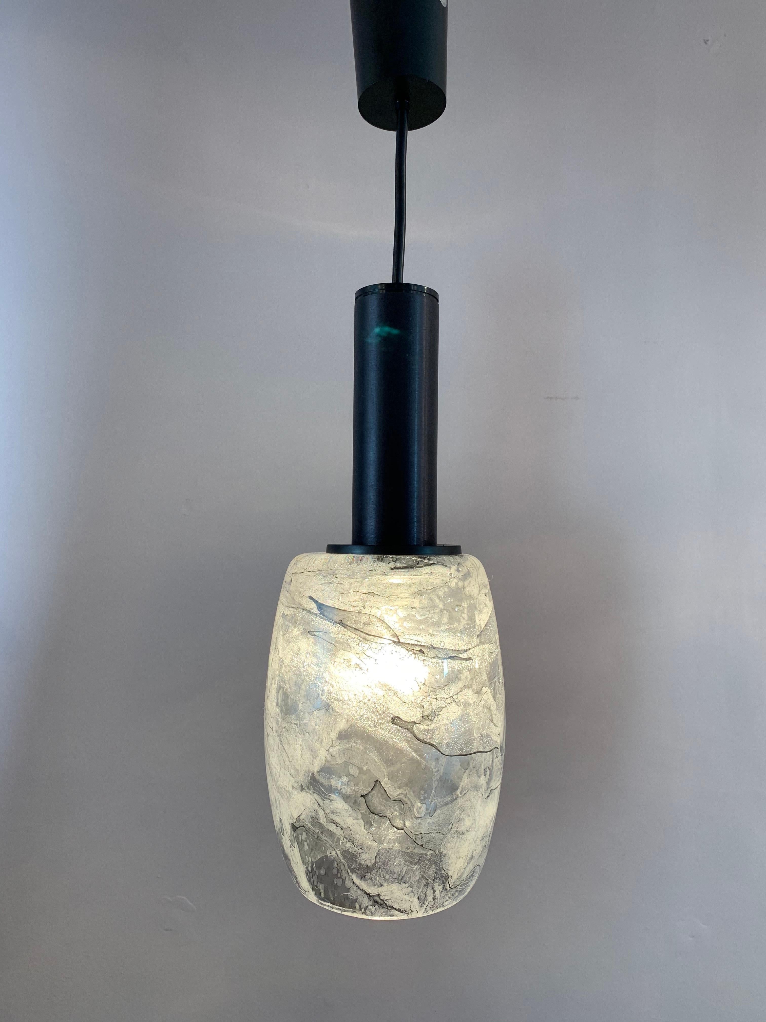 An unusual pair of grey, white and black marble effect hanging pendant lights manufactured in Germany by Peill & Putzler in the 1970s. The thick hand blown glass shades with black metal fittings which are suspended from a height adjustable wire