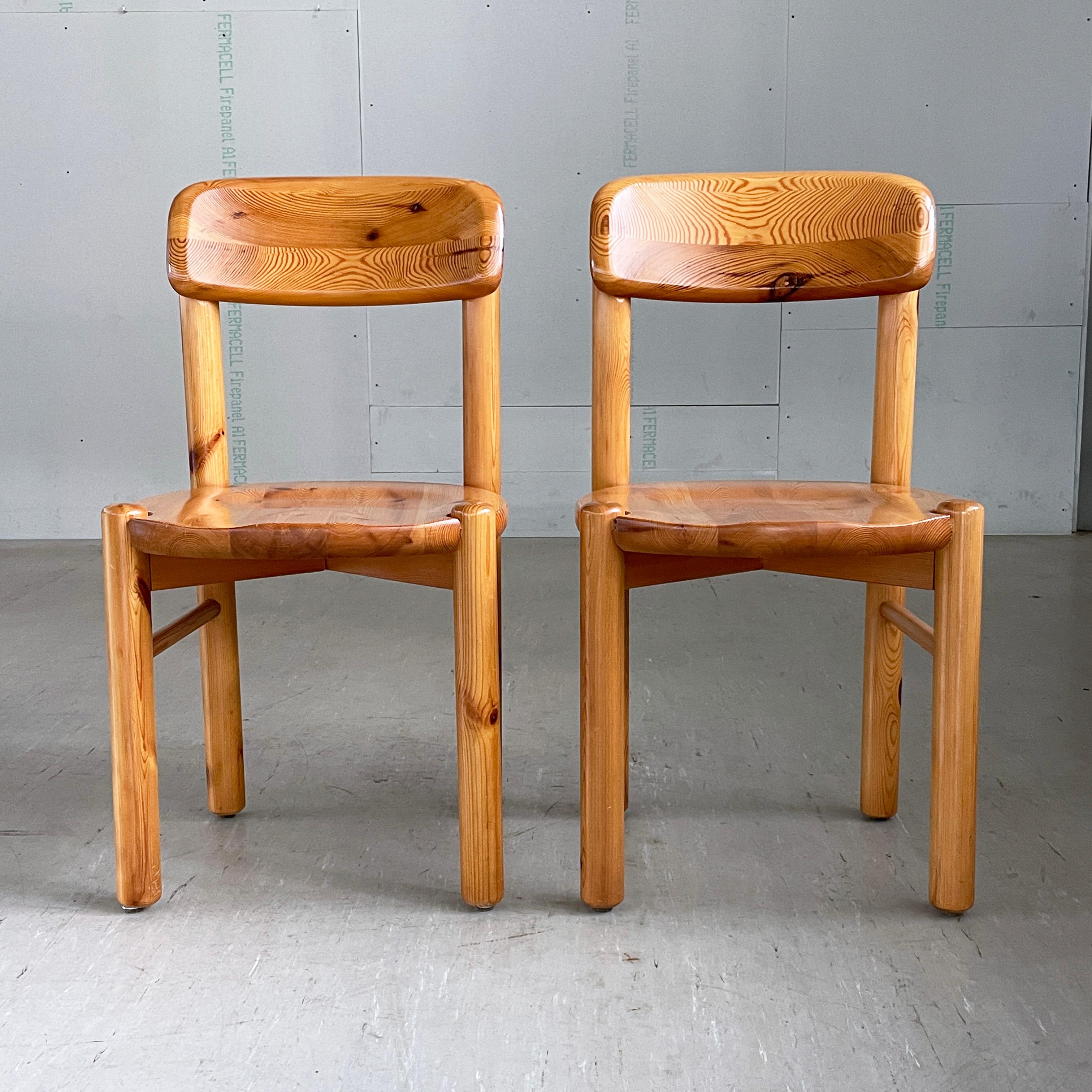 Pair of 1970's Rainer Daumiller Danish modern dining chairs. Solid pinewood construction. Curved backrest, recessed seat with cylindrical lags. Scandinavian minimalism in Brutalist style. Lovely wood grain and colouring. Produced by Hirsthals