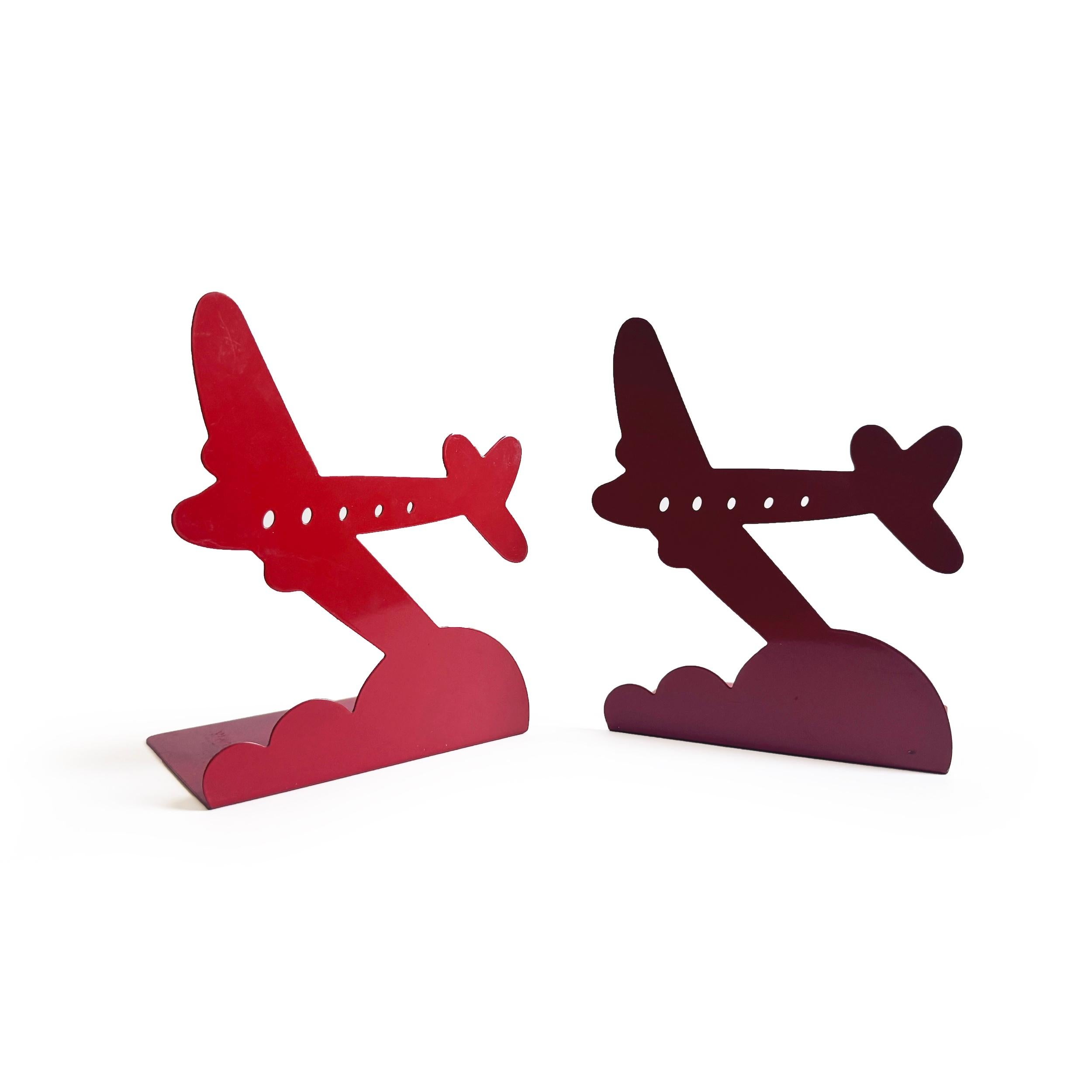 A captivating 1970s aviation-inspired set of bookend that brings playful nostalgic charm and mid-century modern flair to any interior. Designed by Randall Schwartz for Moxie Brand Inc. in 1976, this striking pair feature a finely detailed airplane