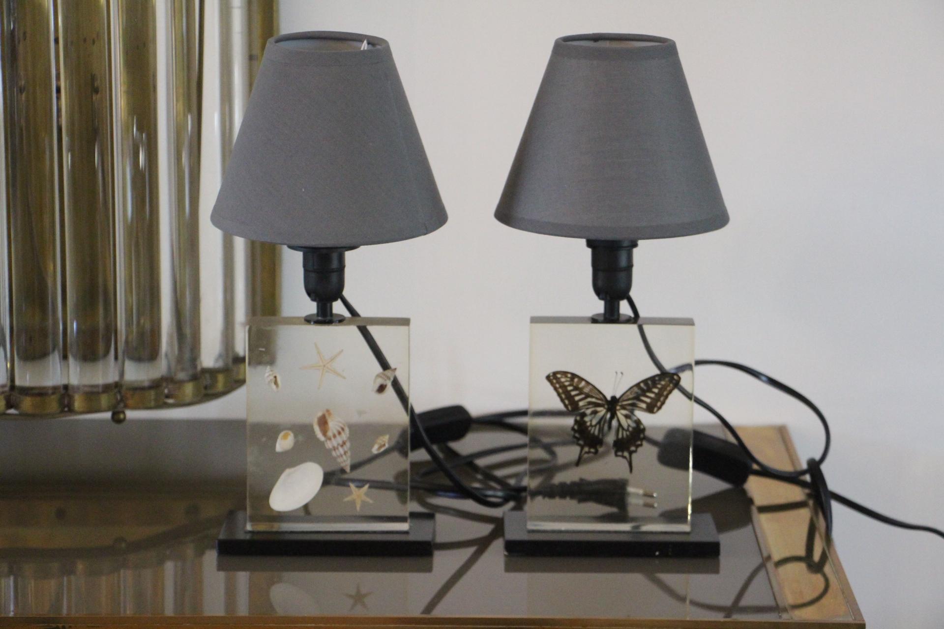 This pair of resin lamps features inclusions of shells and a butterfly and has got clear resin.
Height of the lamps : 9 cm.
They are very decorative.