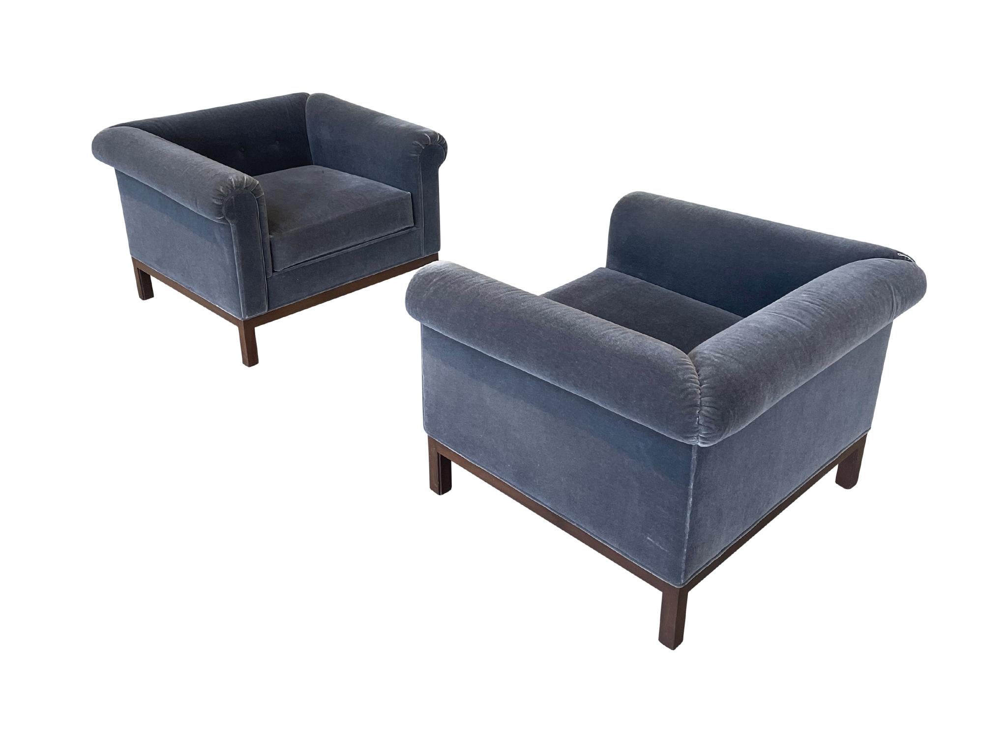 Pair of roll arm chairs designed by Roger Sprunger and manufactured by Dunbar in the 1970s. These classic club chairs have wide arms and backs, ideal for lounging. They have recent upholstery work in a smokey blue mohair that complements the walnut