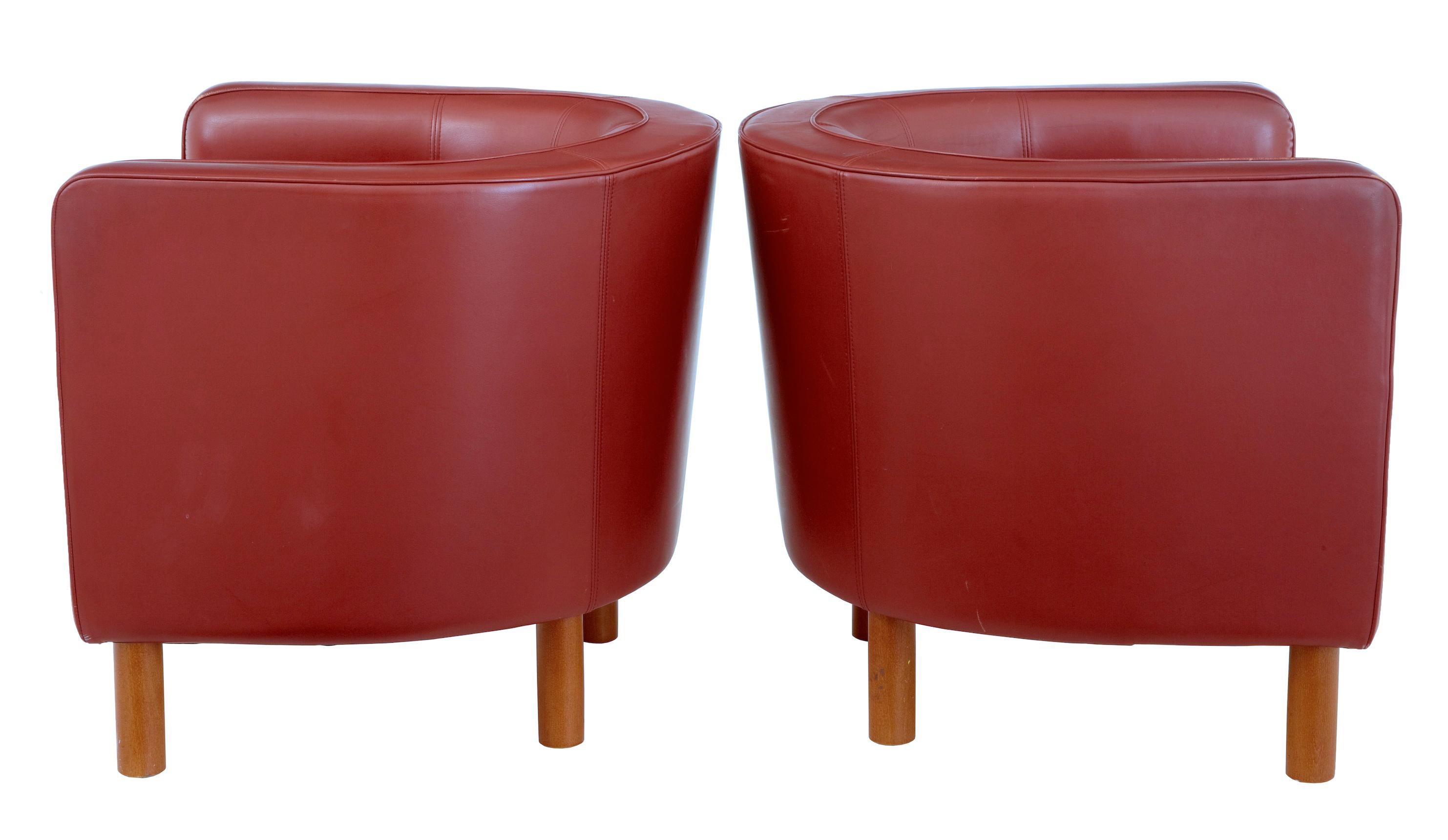 Pair of 1970s Scandinavian large red leather club armchairs, circa 1970.

Upholstered in rusty red leather with matching piping. Beech round legs and exposed front under frame. Very comfortable and stylish. Some wear to leather piping, 1 scuff to