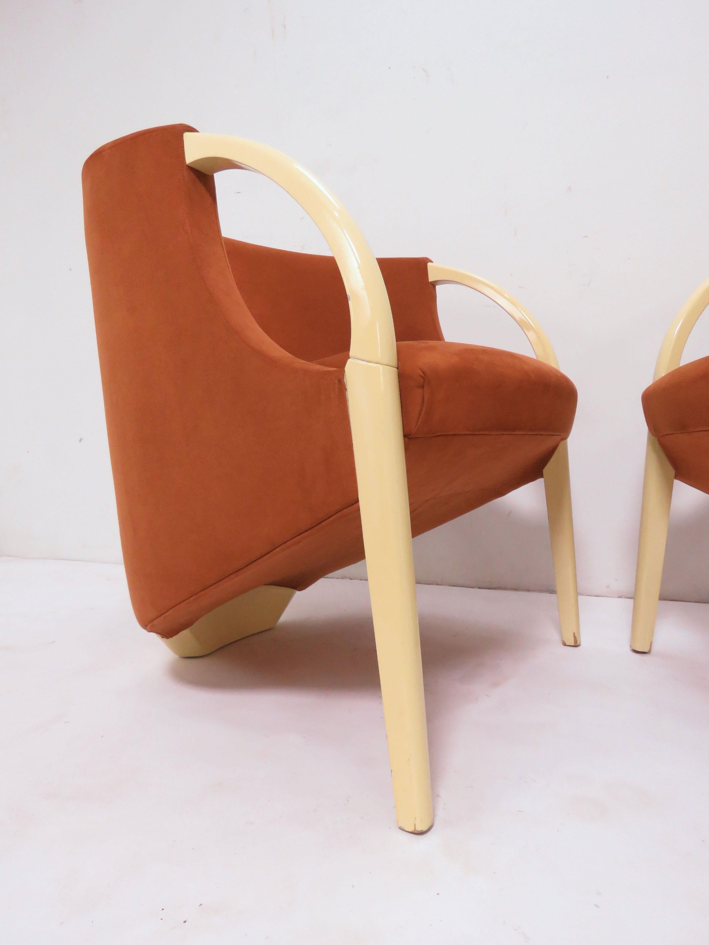 Pair of sculptural lounge chairs, circa 1970s, in original burnt orange ultra-suede upholstery with ivory lacquered arms and frames. Unusual three-legged construction reminiscent of a design by Vladimir Kagan.