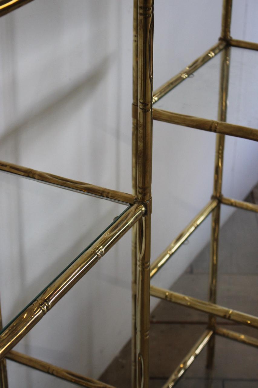 An stylish pair of circa 1970s Spanish faux bamboo brass étagères with glass shelves.