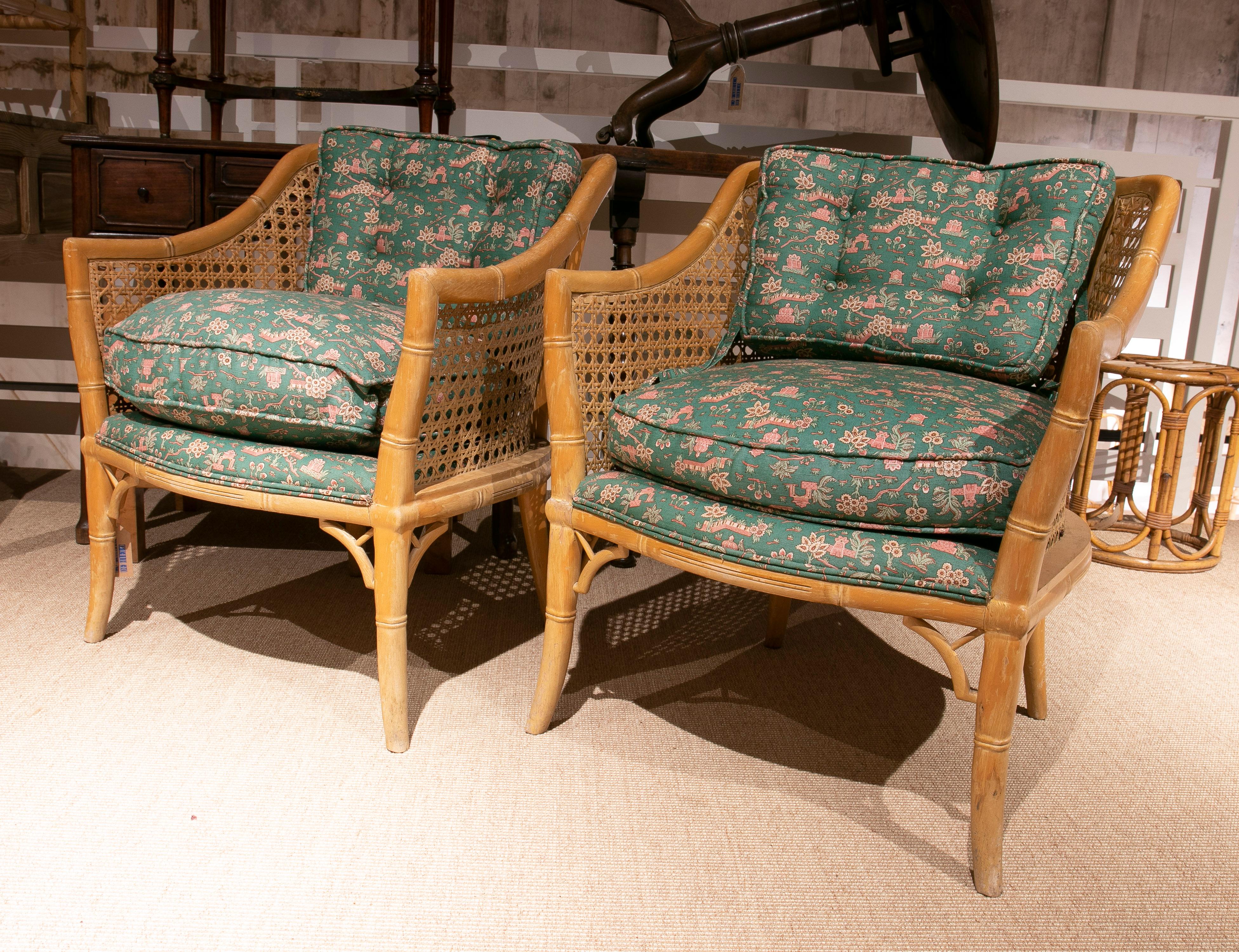 Pair of vintage 1970s Spanish woven cane and faux bamboo wooden upholstered armchairs with matching cushions.