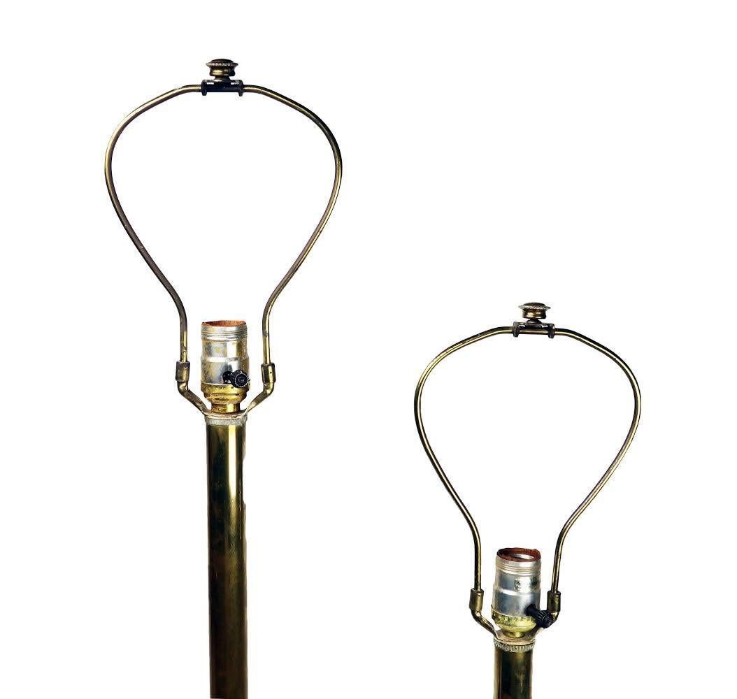 A wonderful pair of sculptural Mid-Century Modern / Hollywood Regency style brass table lamps attributed to designer Tommi Parzinger. Each lamp has three stacked orbs on a square x-shaped jack base to give them a sculptural look and a monumental
