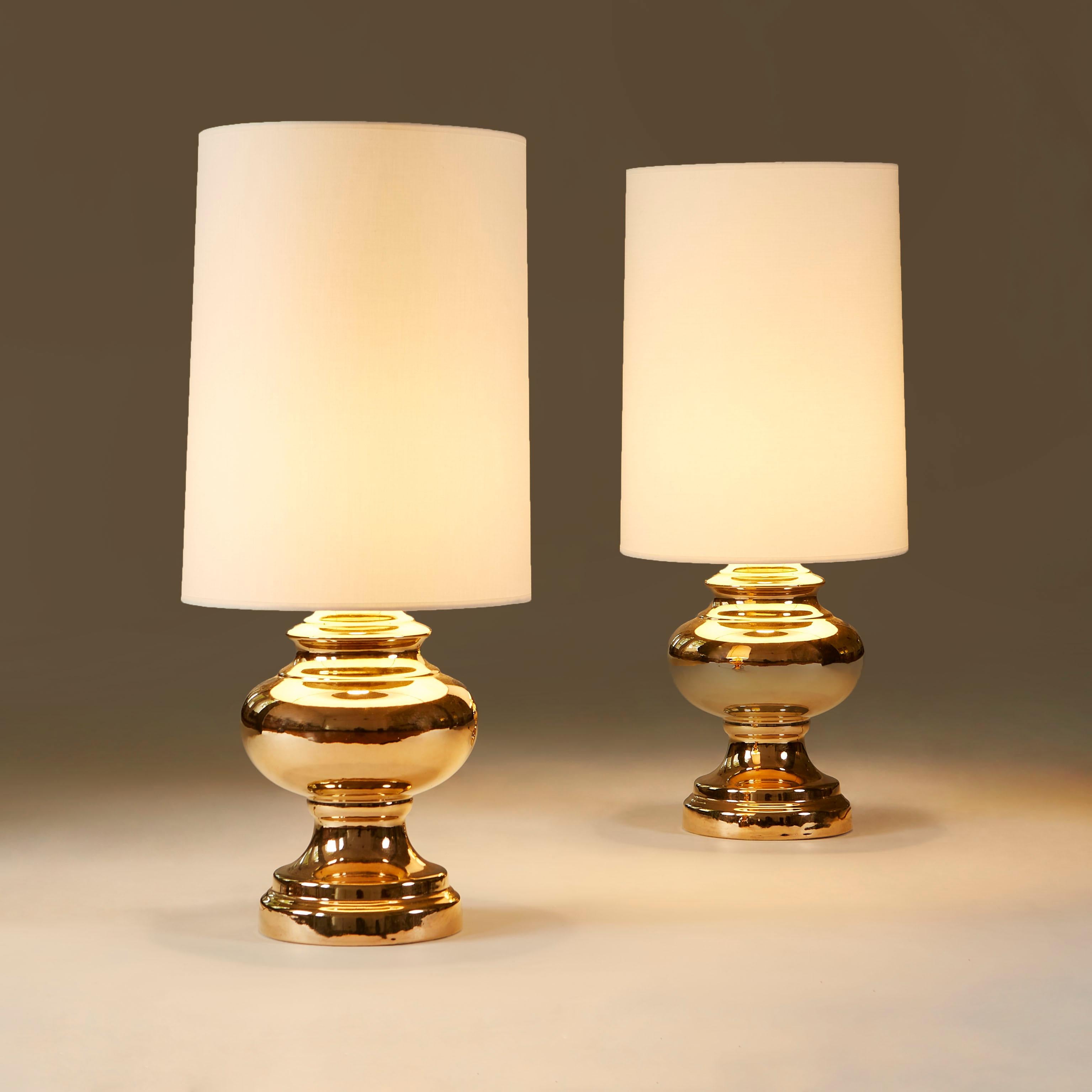 Curvaceous and substantial porcelain table lamps gilded in warm gold. Includes new pair of custom made lampshades.
Height given includes the shades.
 
