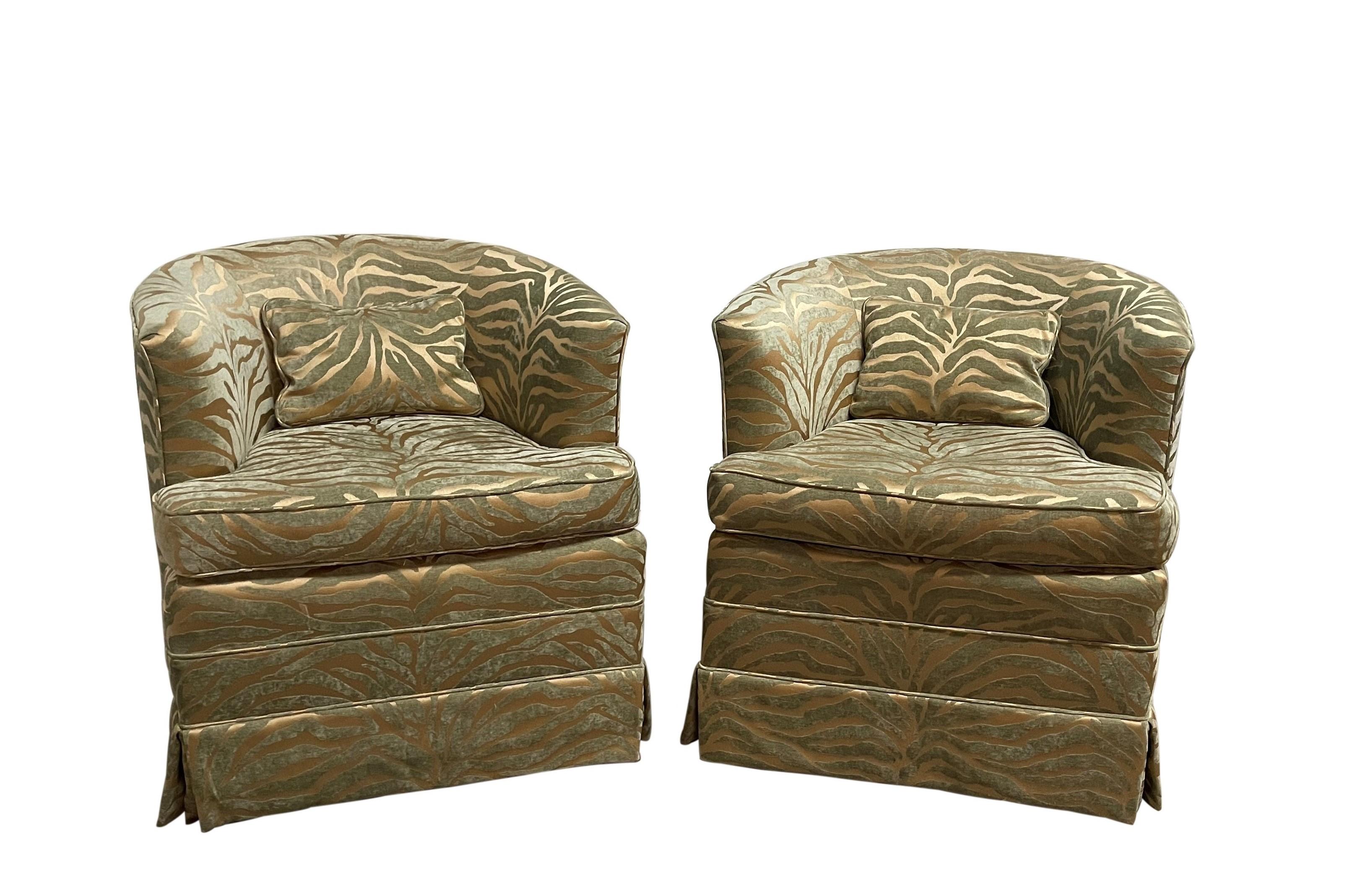 Two fabulous Milo Baughman style barrel back lounge chairs. Modernist swivel chairs upholstered in a bold raised velvet, has a striking luxurious shimmer. A skirt covers a four legged, metal base with a swivel top. Stylish and ideal seating suited