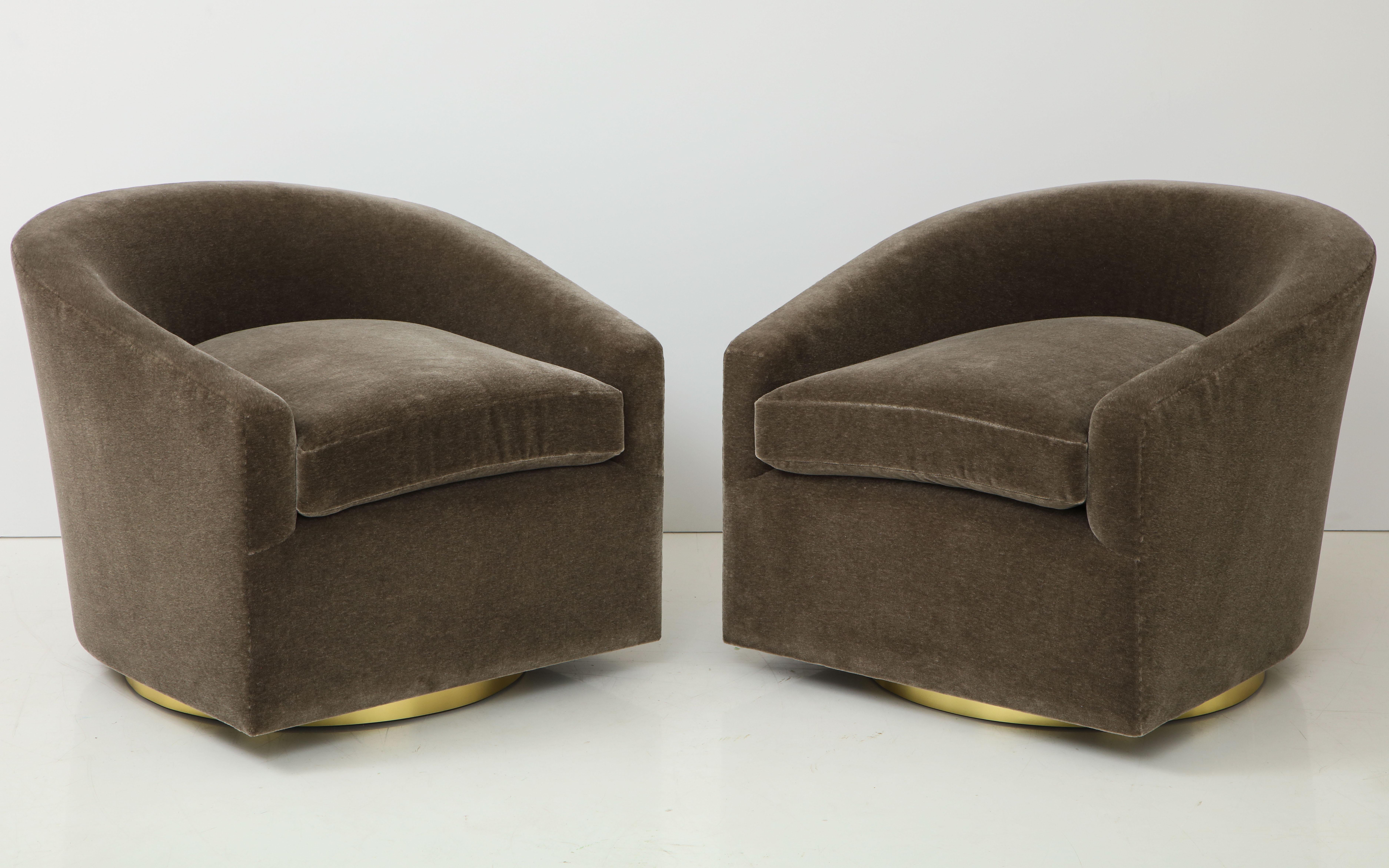 Pair of 1970's swivel club chairs.
The chairs have been newly reupholstered in a luxurious
Taupe brown mohair fabric.
The chairs sit on brass trimmed swivel bases.