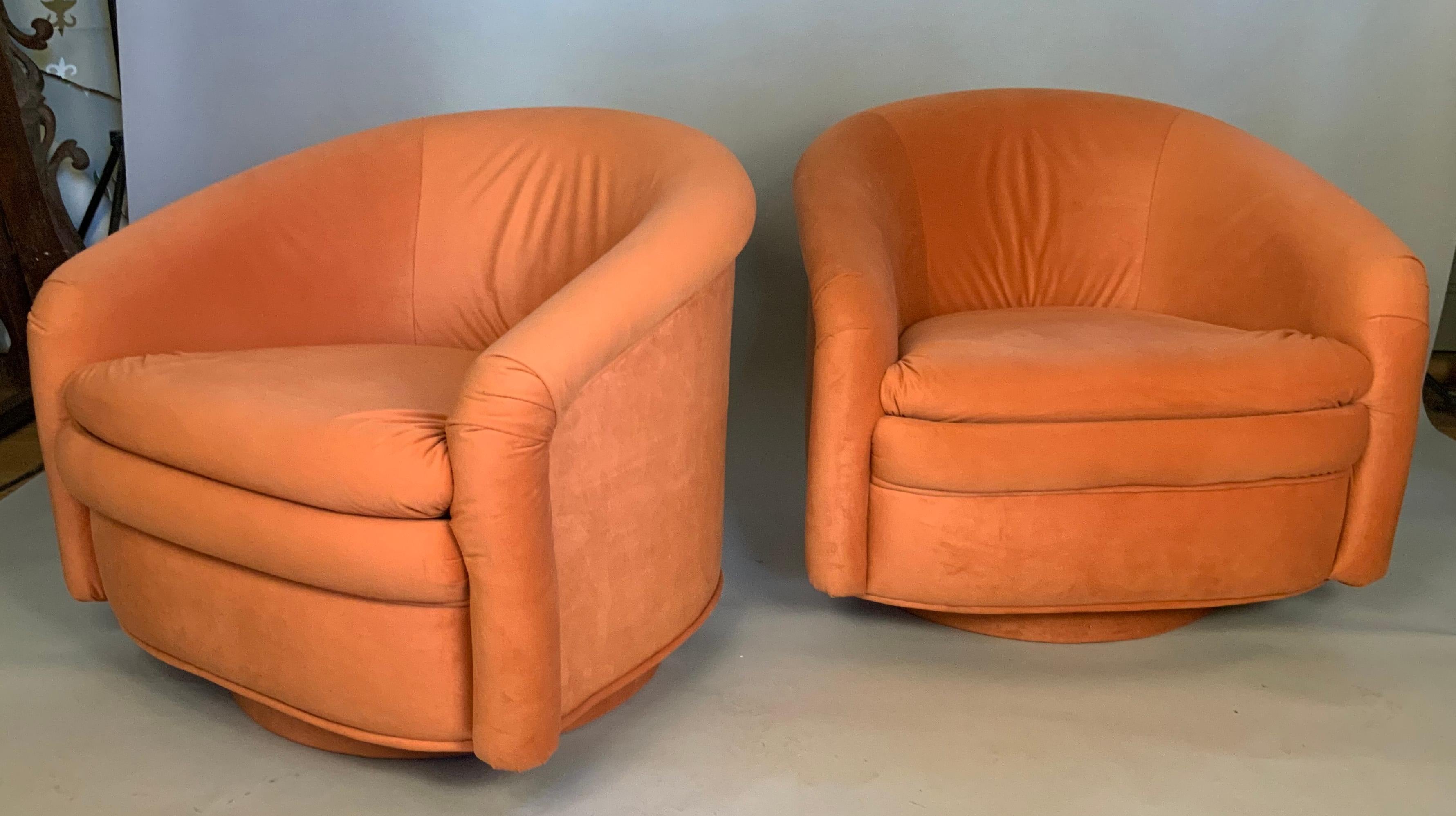 A very stylish and extremely comfortable pair of vintage 1970's swivel lounge chairs, with rounded backs and upholstered swivel bases. great scale and details - in their original orange fabric, which has light wear.
