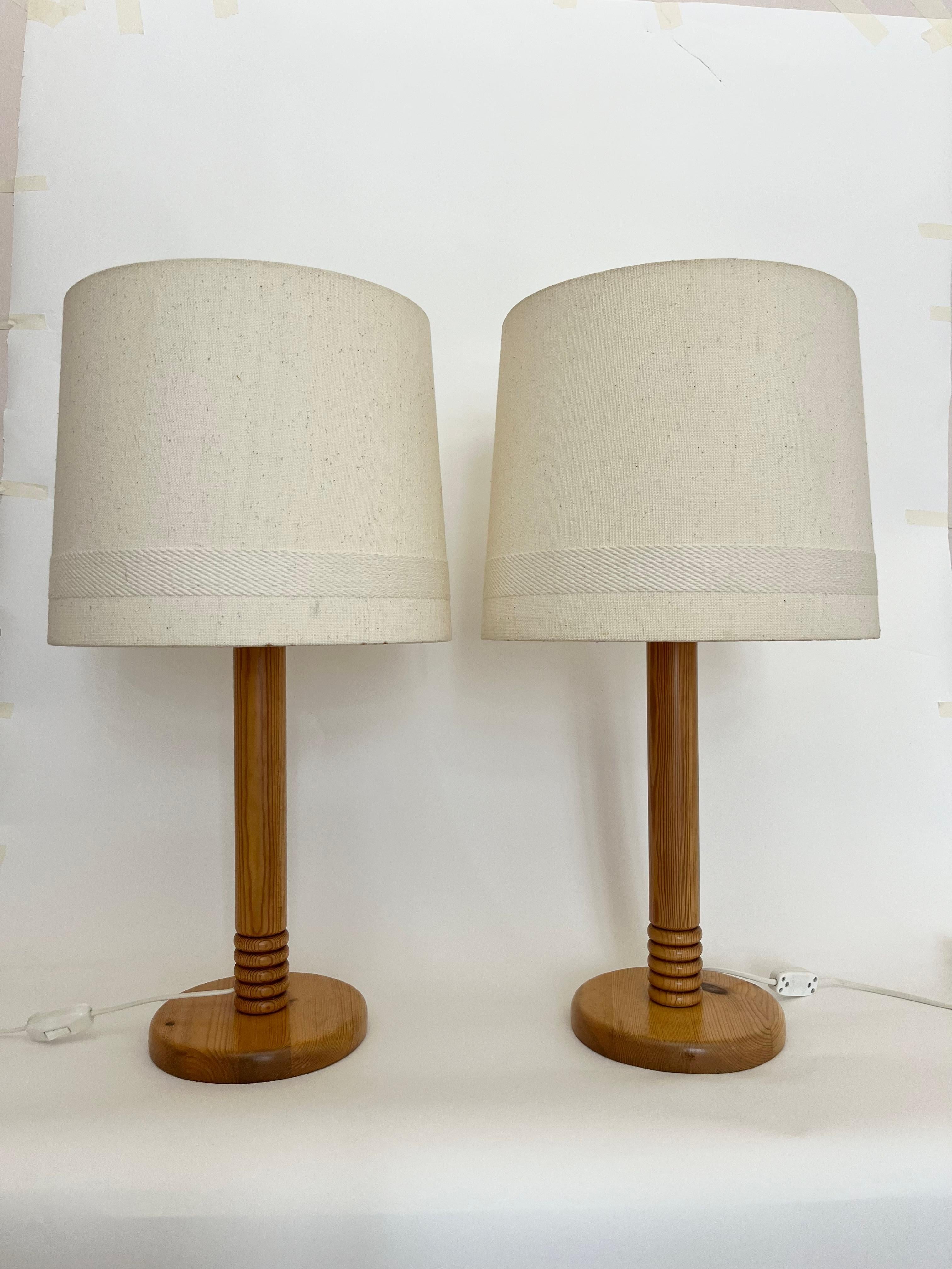 Dieses Paar dänischer Holztischlampen aus den 1970er Jahren ist groß und unaufdringlich beeindruckend. Mit den Originalschirmen in hellem Elfenbeinton mit gewebten Verzierungen/Details. 

Höhe: 66 cm (26.0 in) mit dem Schirm // Höhe: 43 cm (16.9 in)
