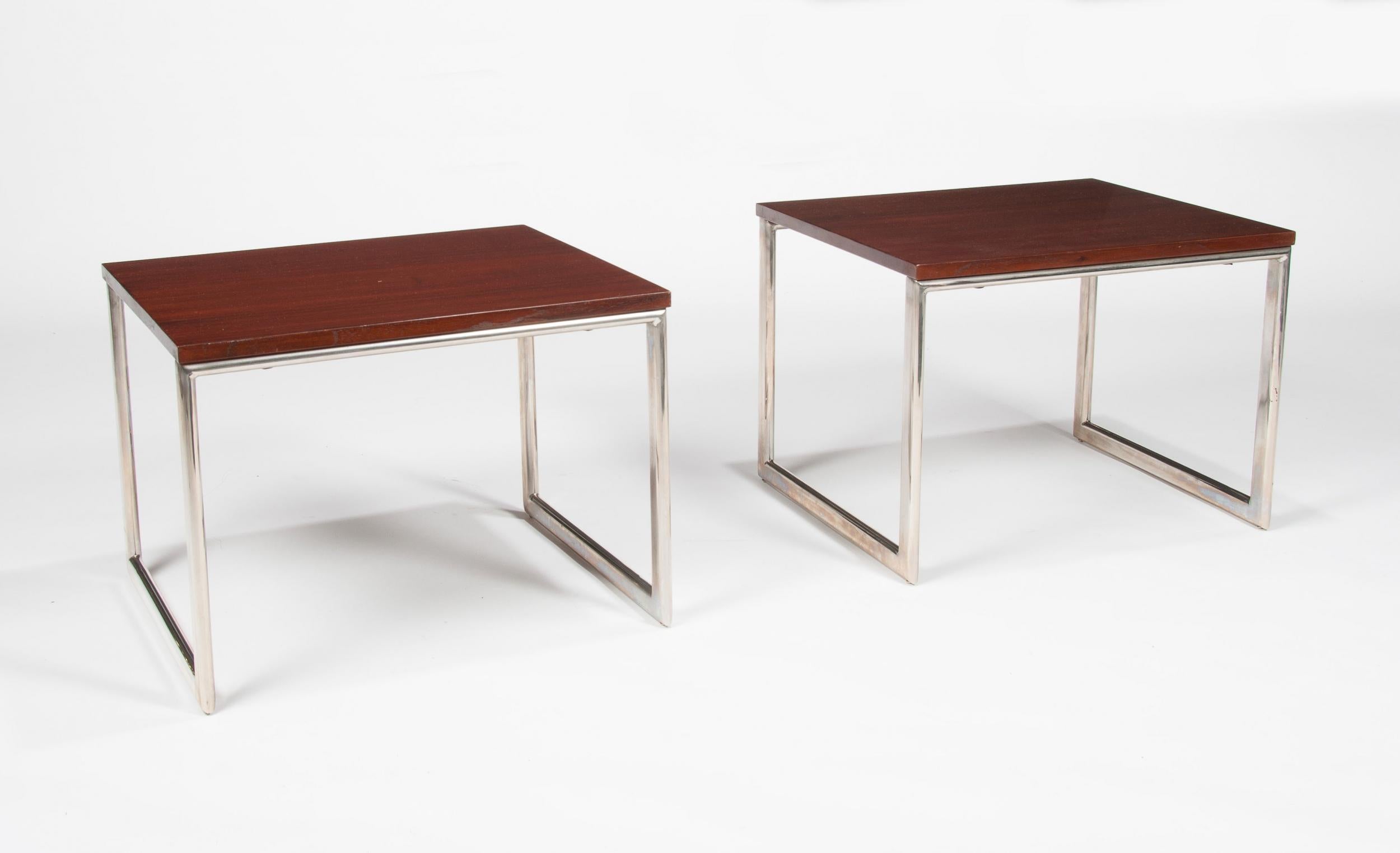 A contemporary pair of teak and chrome side or end table dating to circa 1970s.



Each table having a rectangular polished teak top with an tubular chrome shaped base.



Offered in excellent condition with the tops and base having been
