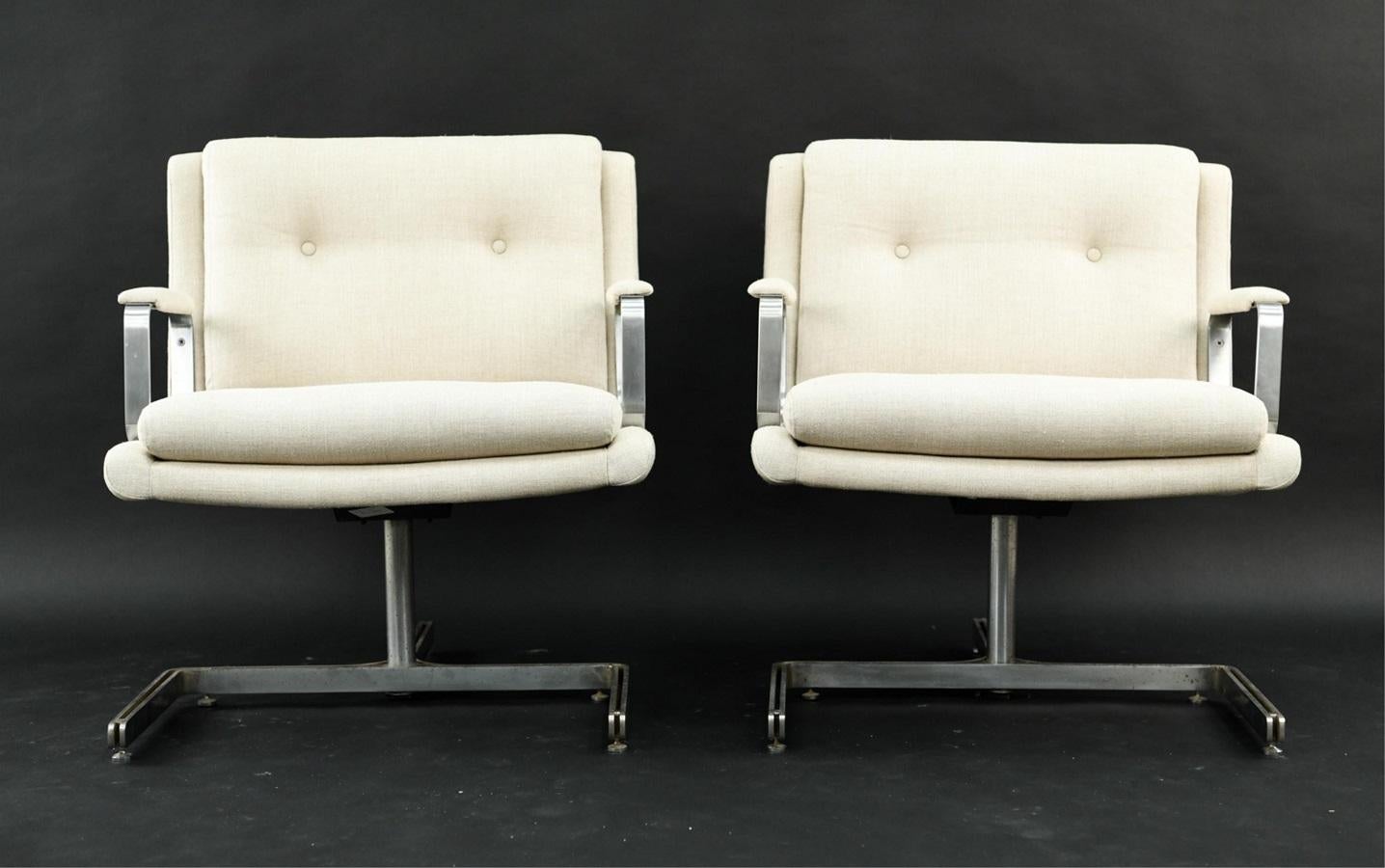 Pair of 1974 Raphael Raffel armchairs. The chairs have an off-white linen blend upholstery with a stainless steel tripod shaped frame.