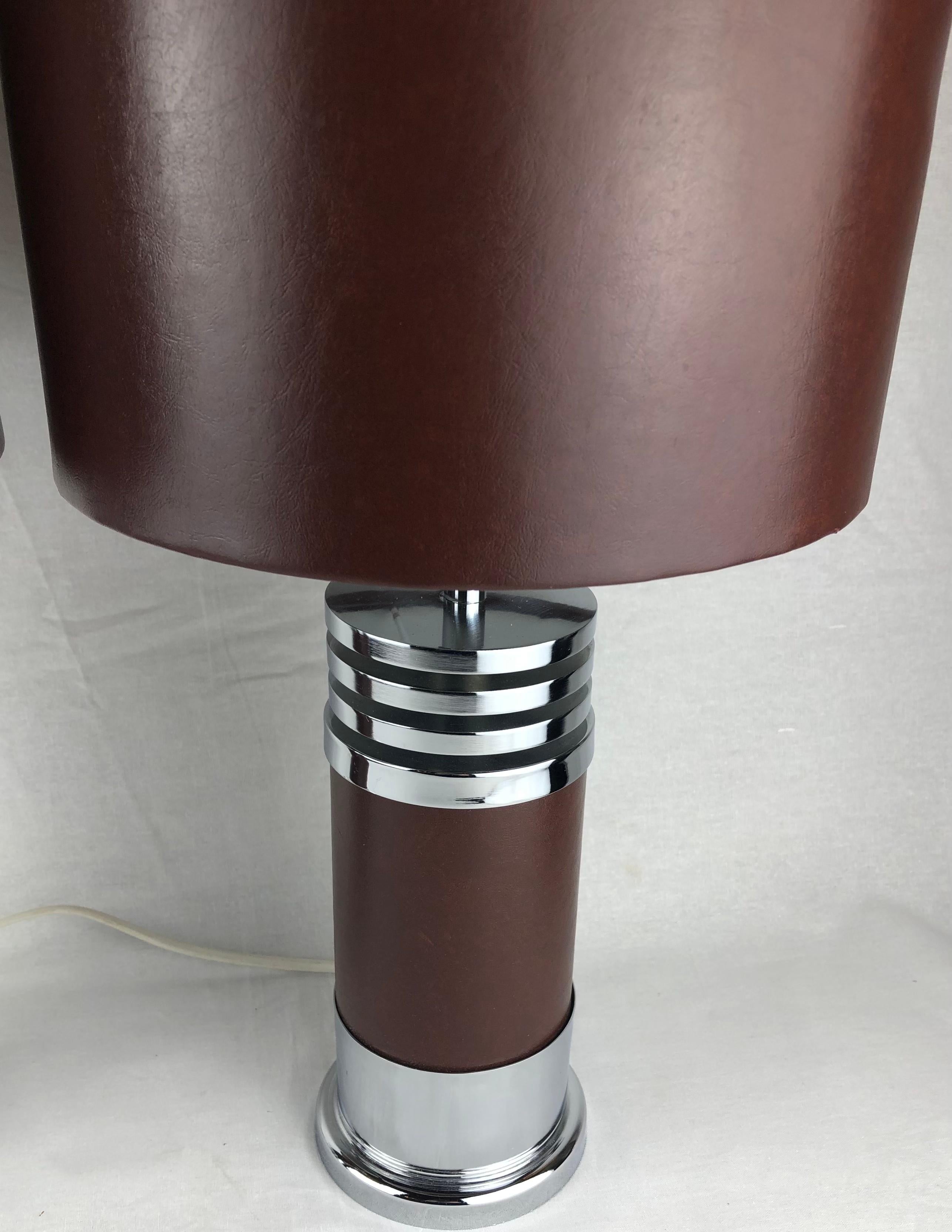 A sleek pair of chrome table lamps designed for Roche Bobois.
These are delightfully heavy pieces with fine workmanship. 
The center supports circular lamp shades featuring very good quality faux leather. 

Manufactured in France, circa 1975.
Wired