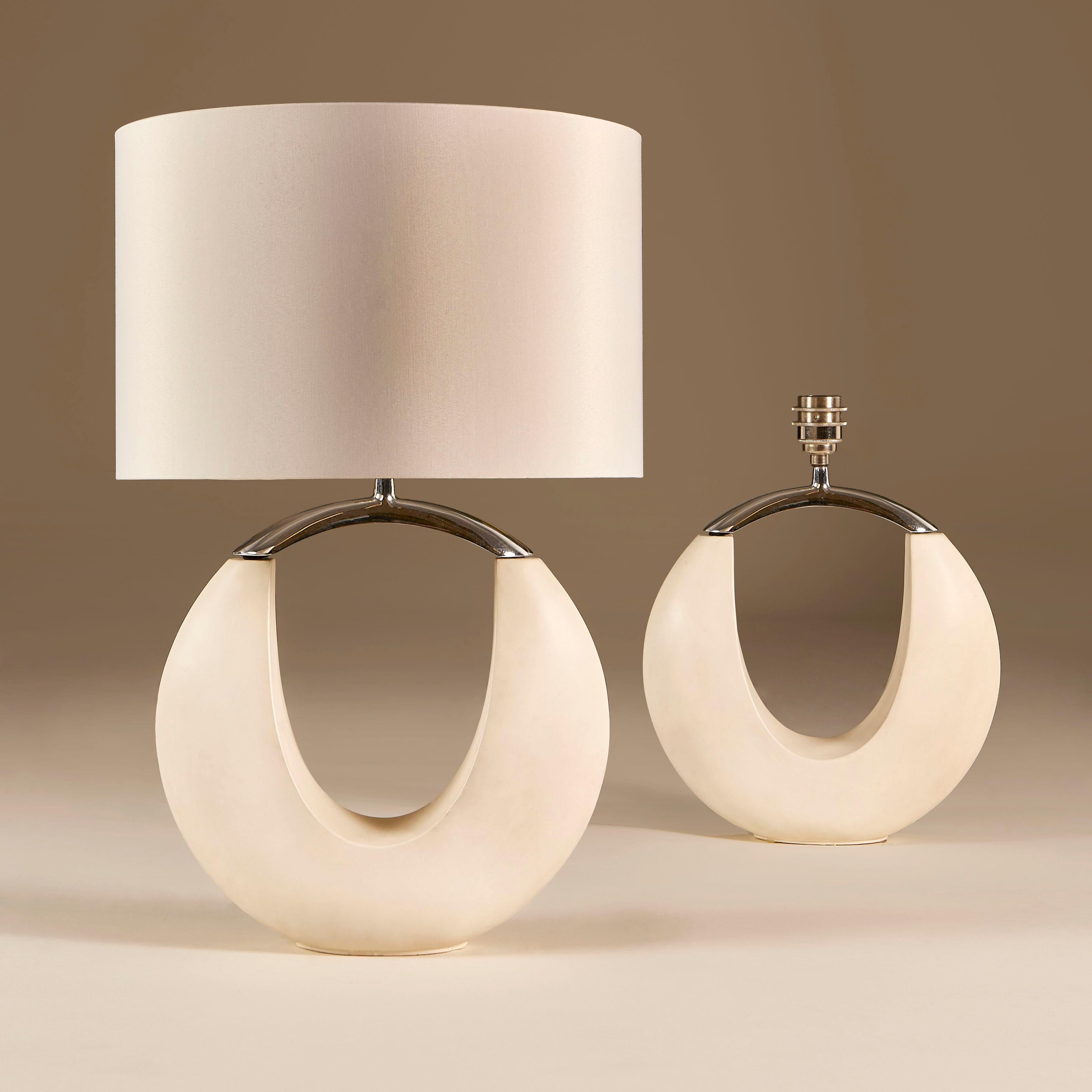 Smooth scultupural cream stone shaped lamps with chrome top.
