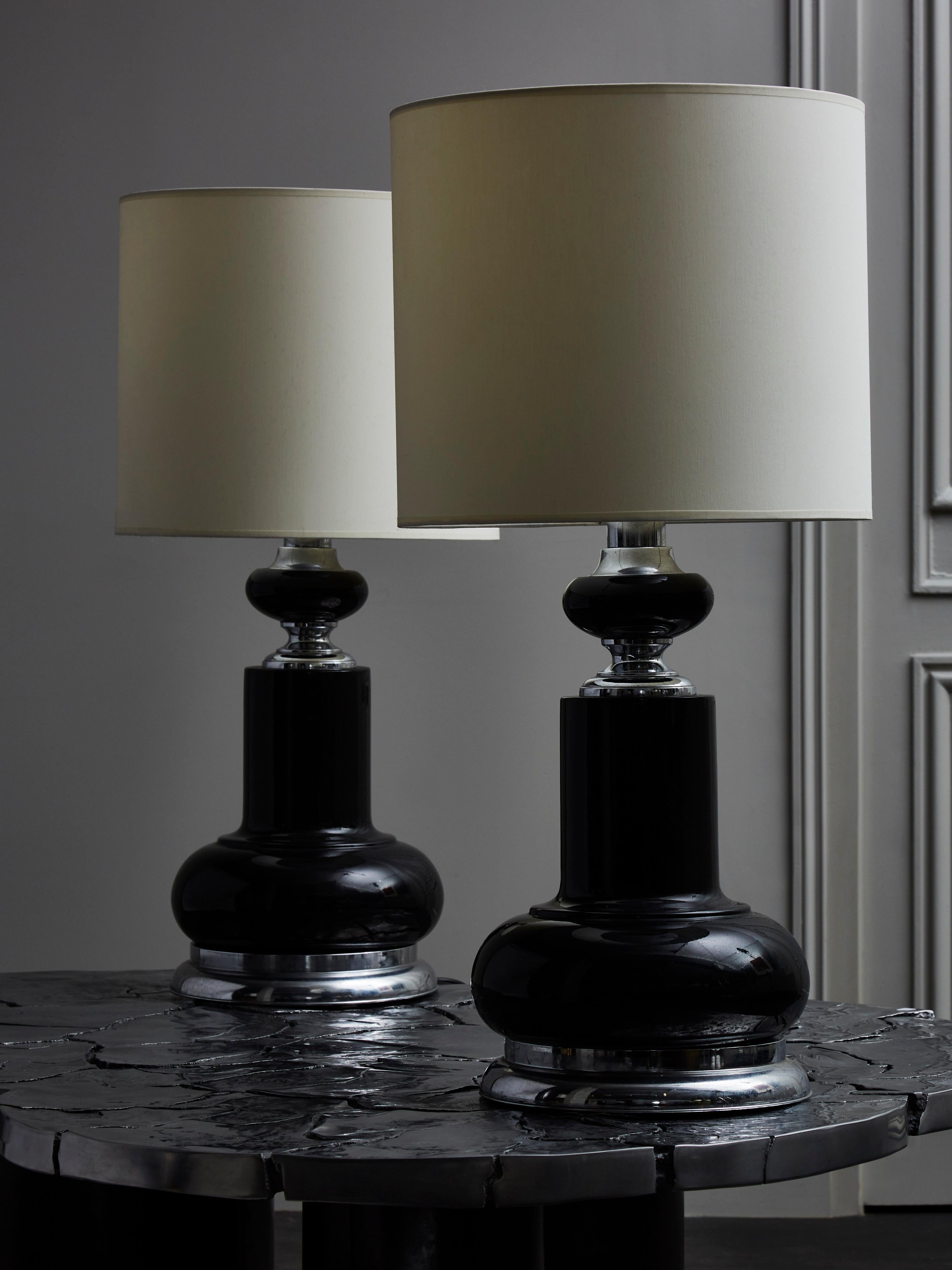 Ein Paar große Tischlampen aus schwarz emailliertem Metall mit polierten Details wie den Füßen und Hälsen der Lampen.
 
  