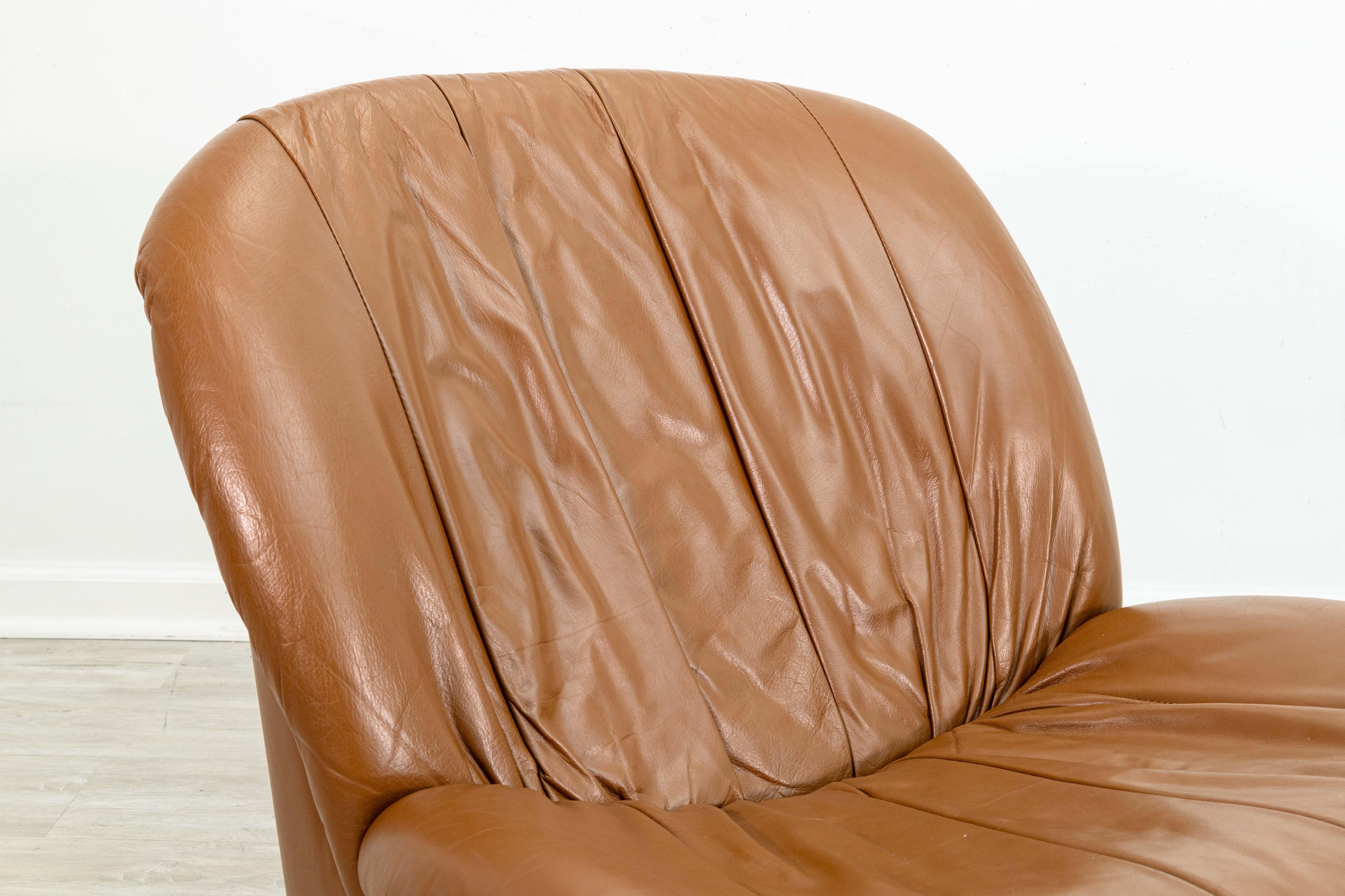 A pair of 1980s brown leather swivel glider lounge chairs. These lovely accent chairs are made by Glenn Furniture Company in the mid 1980s. They have a very chic postmodern styling, with soft, plush brown leather upholstery. Each of these chairs