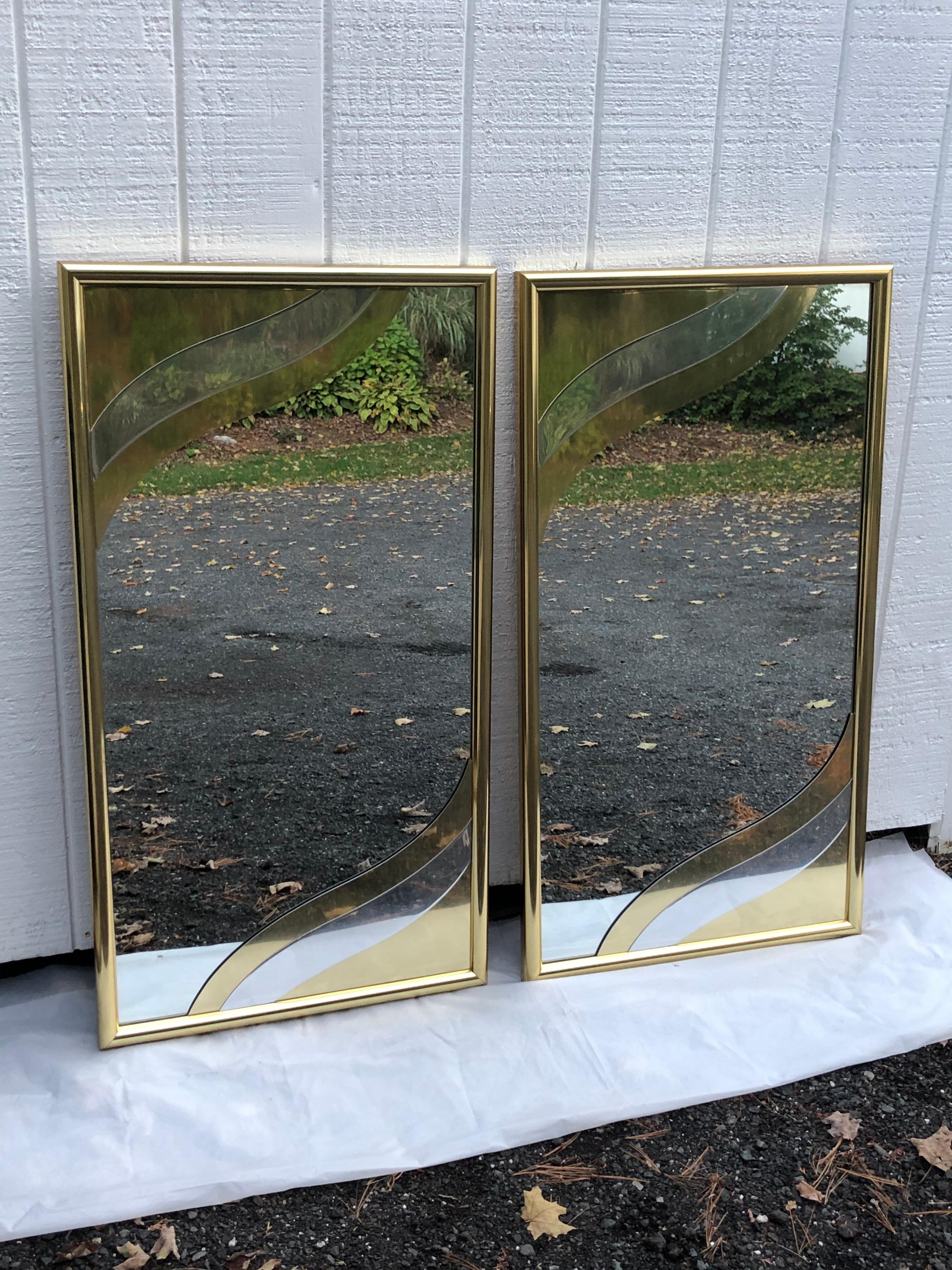 Pair of Rare 1980's designer brass mirrors in the style of Curtis Jere. Amazing 3 D style design. Perfect for either above two sinks in a master bathroom or above a credenza. Very heavy and extremely well made high end mirrors. Signed on back autumn