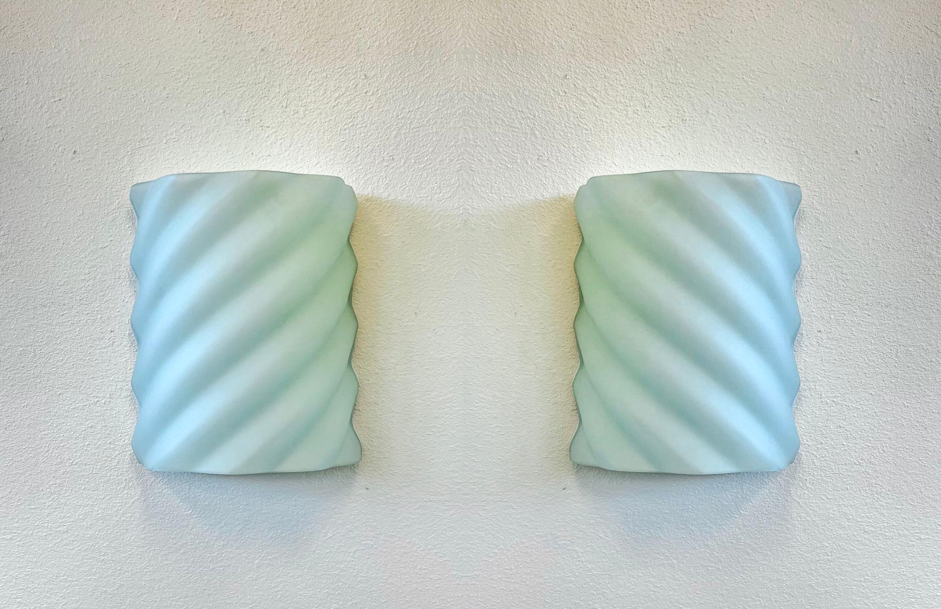 Genial par de apliques de pared de cristal esmerilado de los años 80, obra de Ron Rezek. 
En bonito estado vintage original. 
Cada aplique admite dos bombillas Edison de 75 W máx. 

Medidas: 15