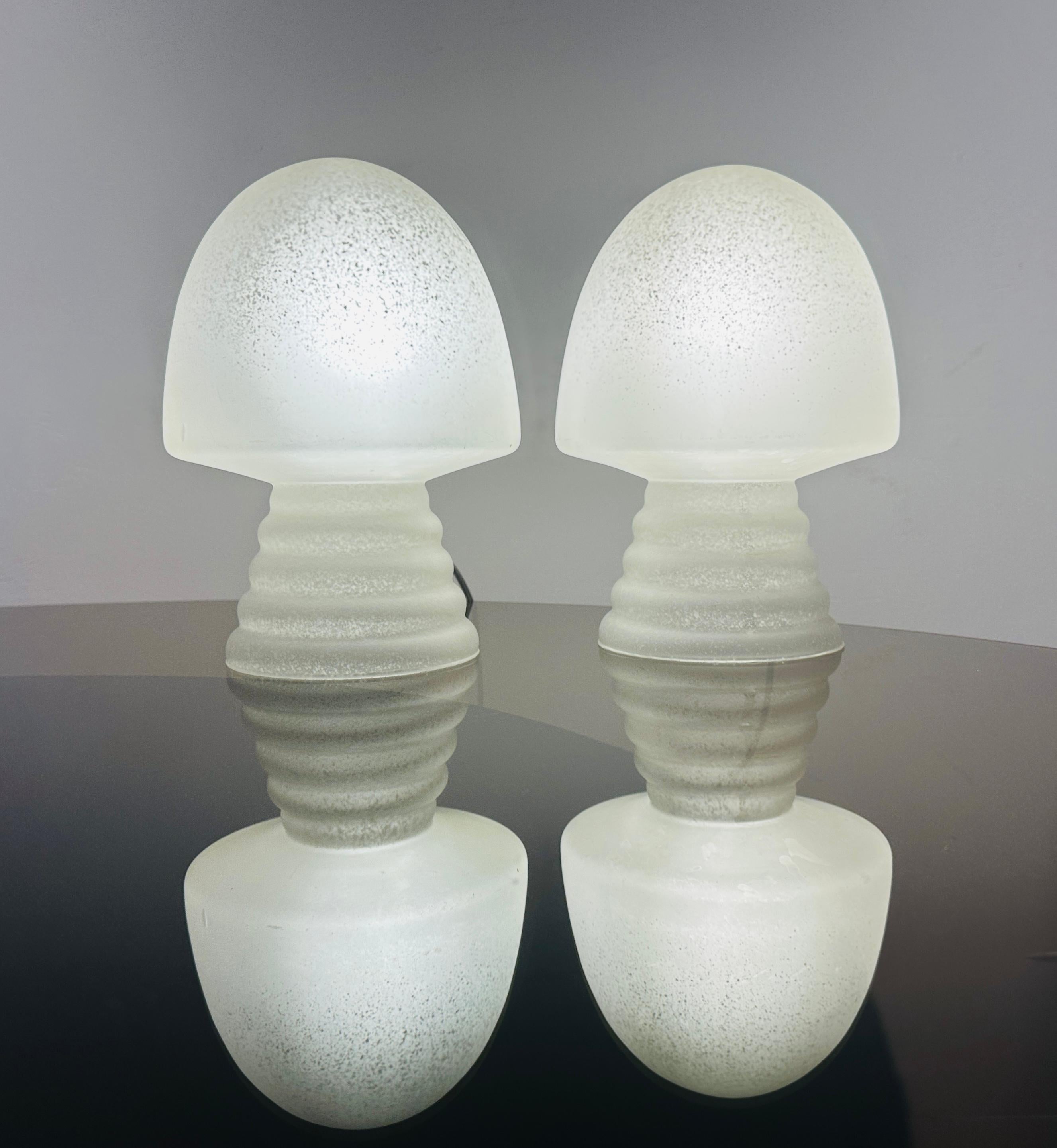 Pair of 1980s space-age frosted speckled satin glass mushroom lamps with a conical concertina base.  The lamps consist of one piece of glass.

Rewired with a plastic transparent flex and matching on/off switch.  Max 25w.  The lamps require a single
