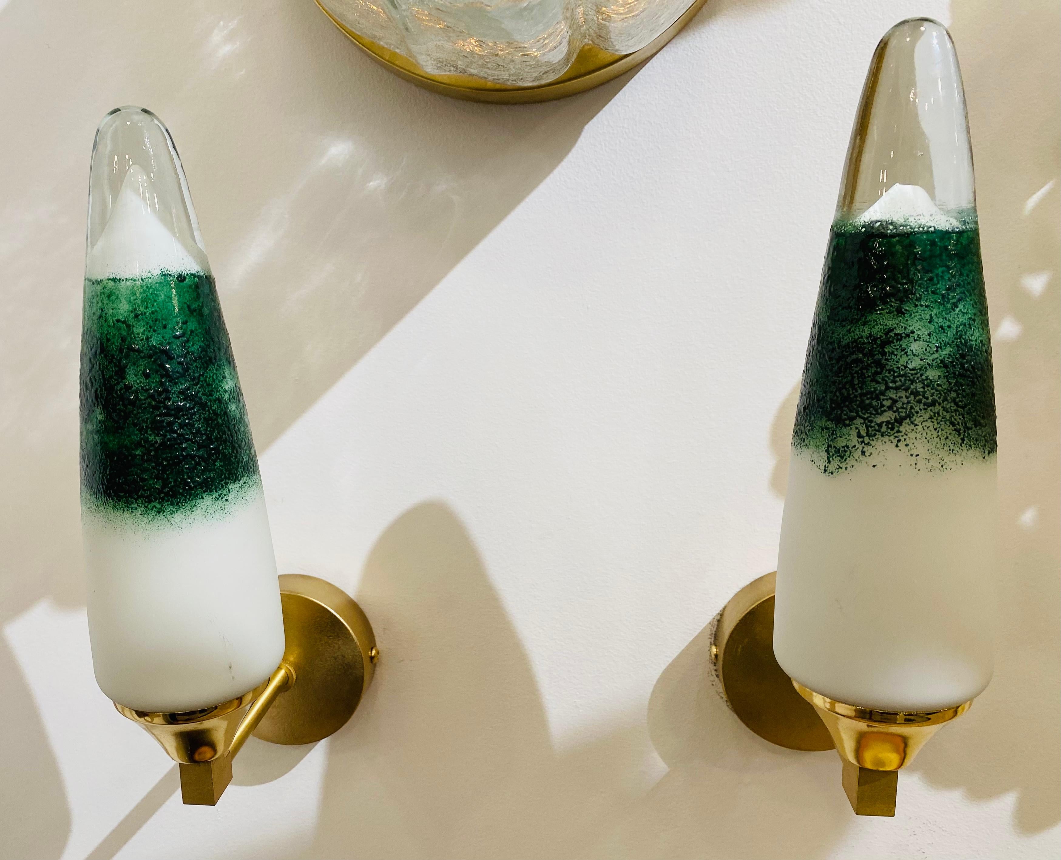 Une superbe paire d'appliques originales des années 1980 avec des fixations en laiton poli et satiné et des abat-jours en verre de Murano vert/blanc/clair soufflé à la main. Recâblé.