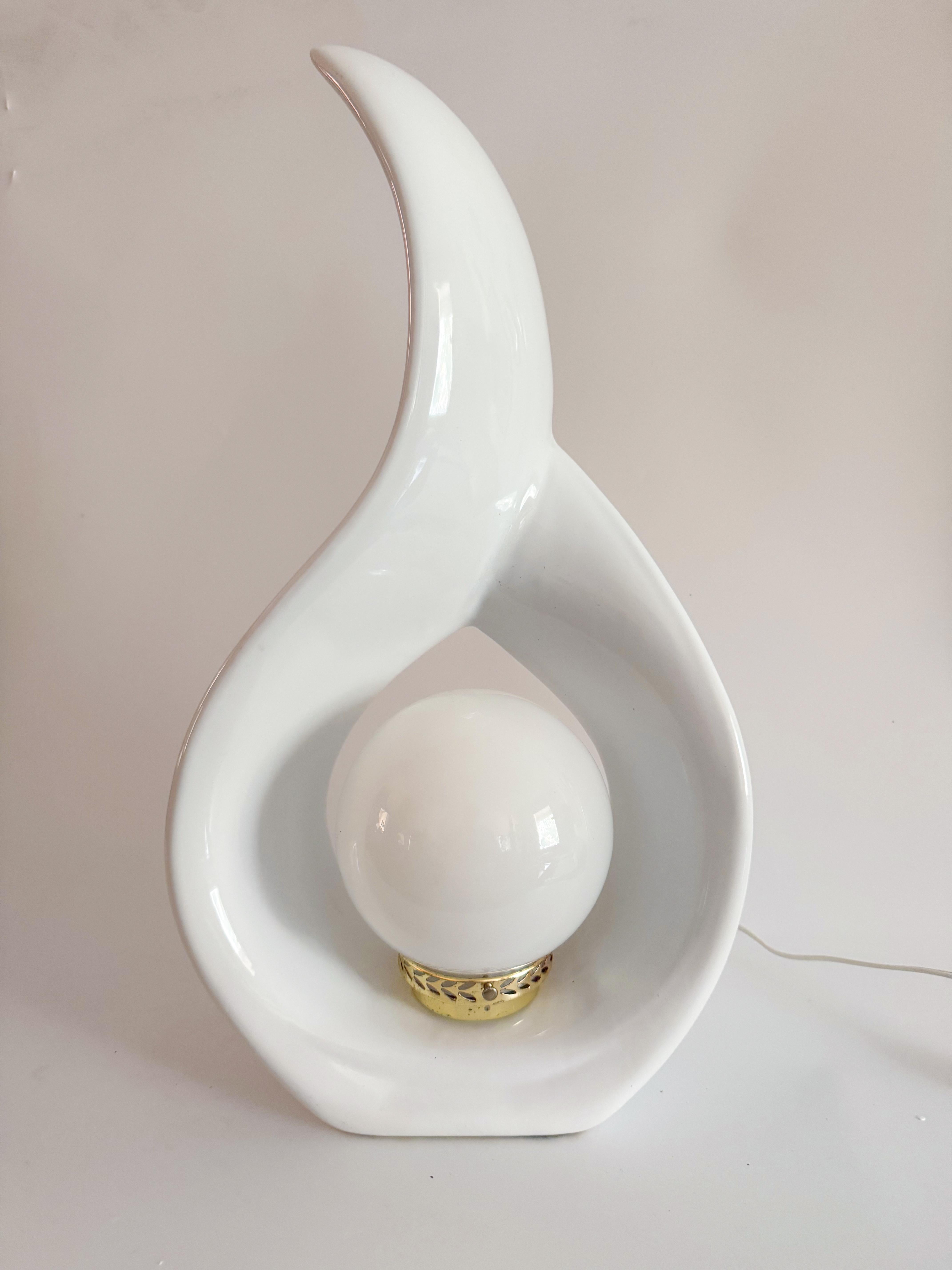 Paire de lampes sculpturales en forme de goutte d'eau des années 1980, avec un beau miroir et une finition en glaçure blanche brillante. Leurs formes fluides, semblables à des rubans, entourent les ampoules orbes blanches, créant ainsi une présence