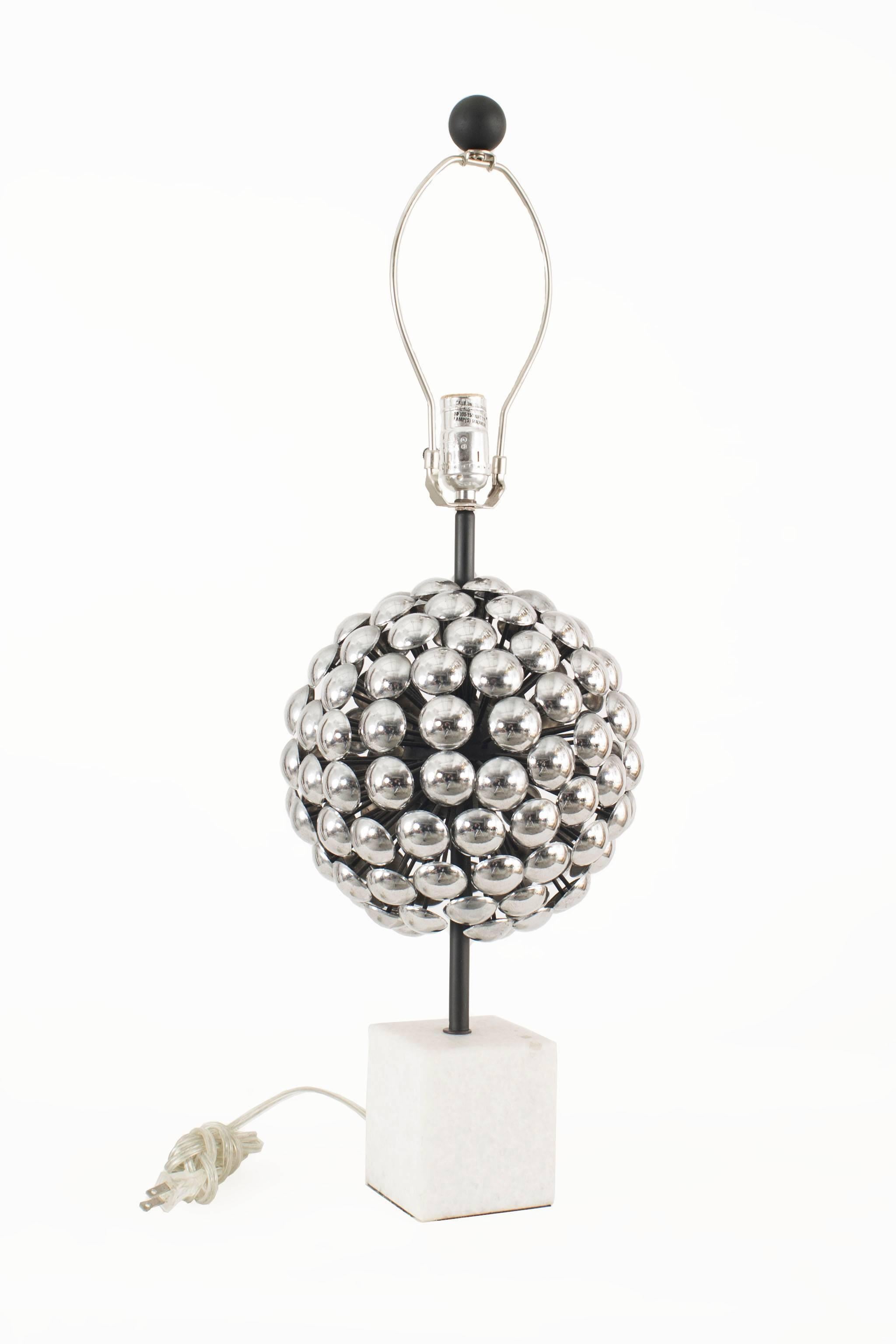 Pair of 1980s (possibly Italian) table lamps with decorative silver metal spheres forming a ball suspended on thin posts resting on square white marble bases. (Shades not included).

 