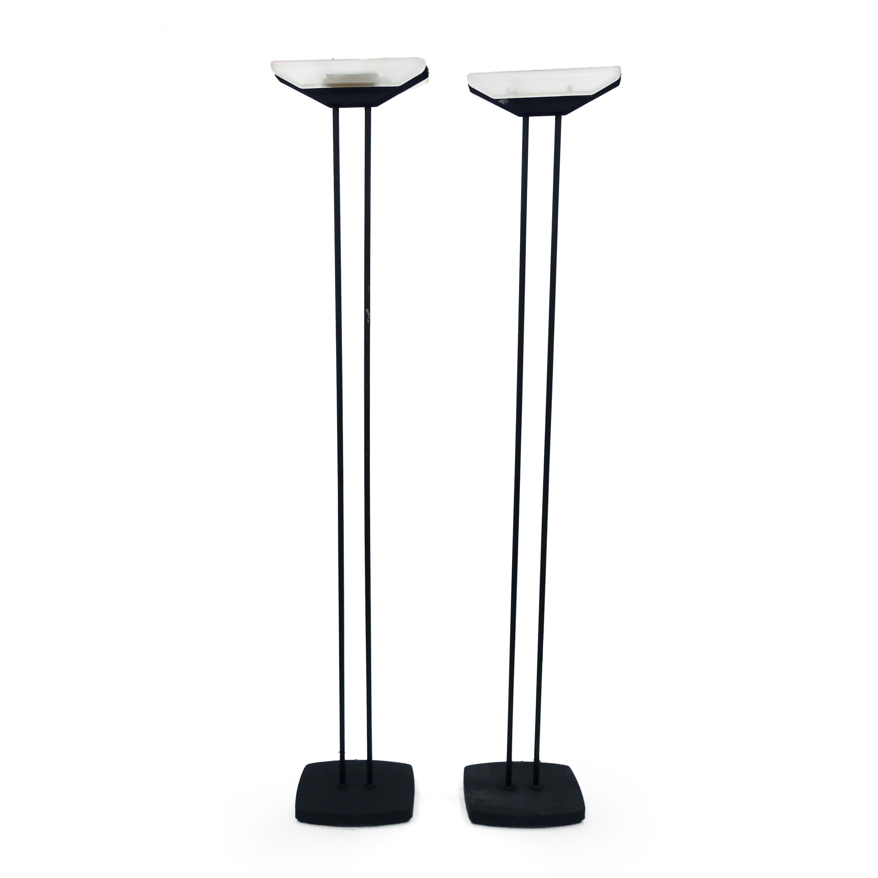 A great pair of 1980s postmodern floor lamps in black enameled metal attributed to Raul Barbieri and Giorgio Marianelli for Tronconi Illuminazione.  With heavy cast metal bases and two metal columns that support a rectangular glass shade, the lamp's