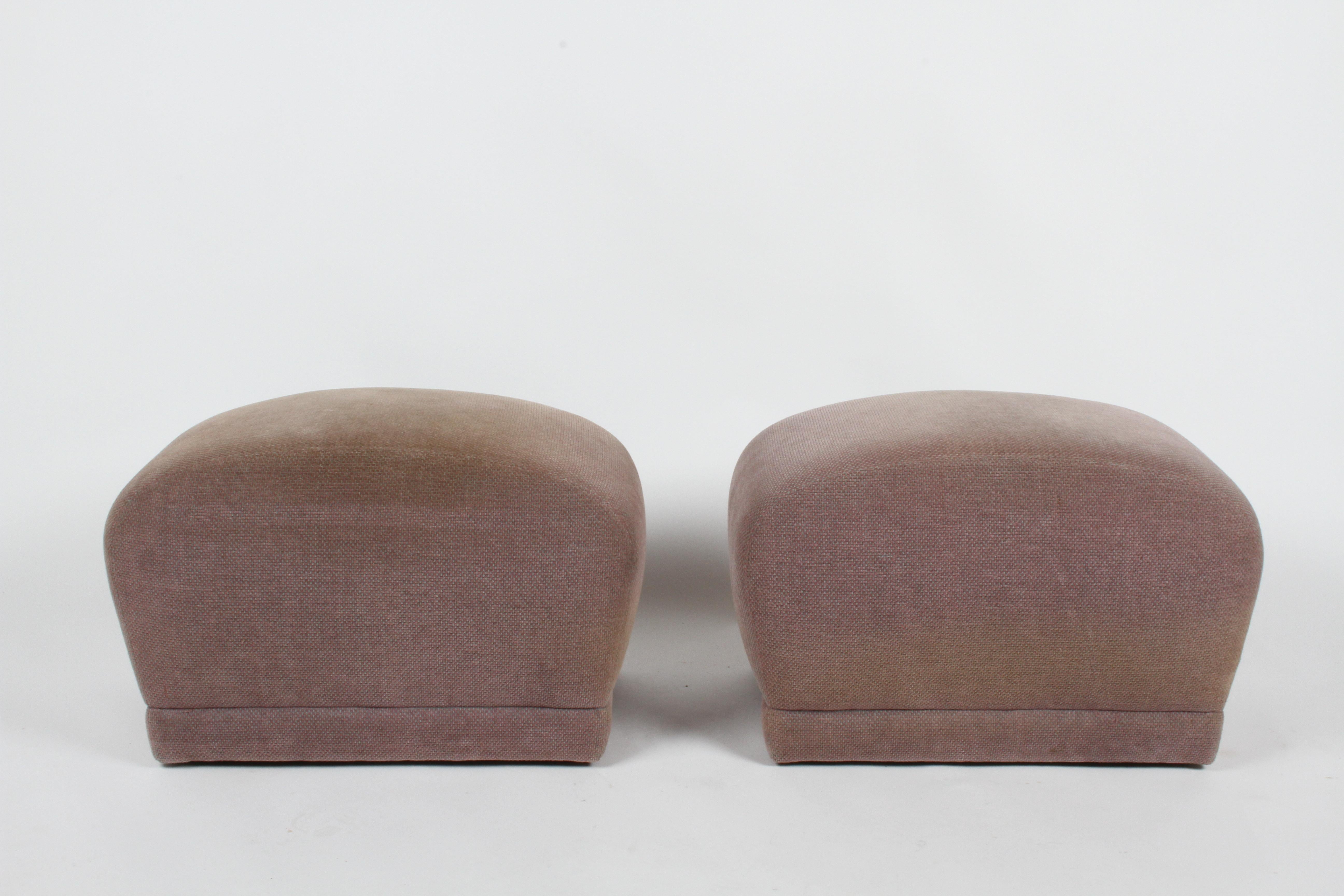 Pair of late 1970s or early 1980s fully upholstered poufs or ottomans on castors by Classic Gallery. Original upholstery in need of reupholstery, castors can be removed if desired, otherwise in fine condition. Label custom made by Classic Gallery.