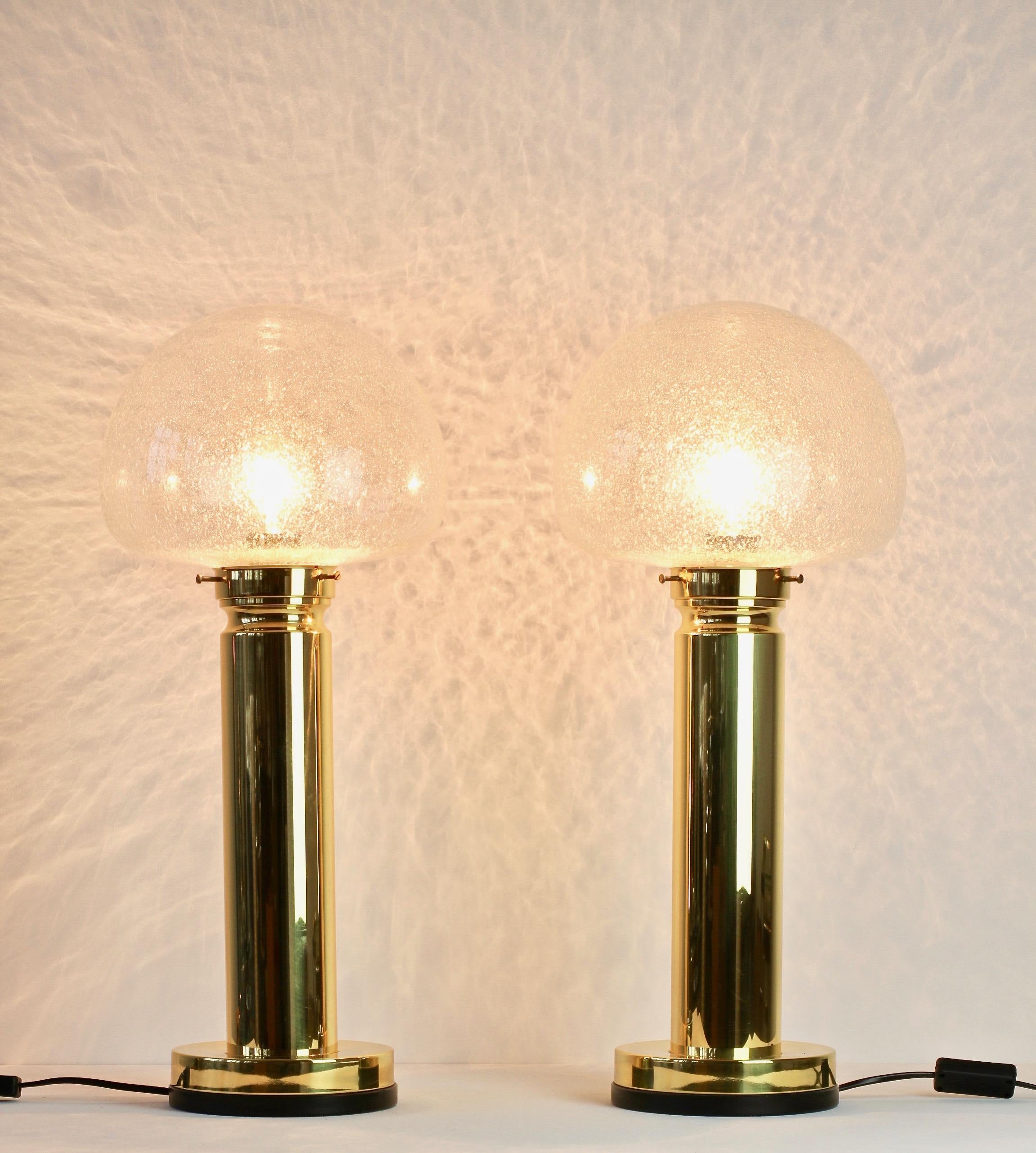 Limburg style large pair of tall table lamps or desk lights. Featuring a round domed mouth blown bubble glass shade and a polished brass base. Being mouth blown each piece of glass represents a unique moment in a glass blower's life and work which