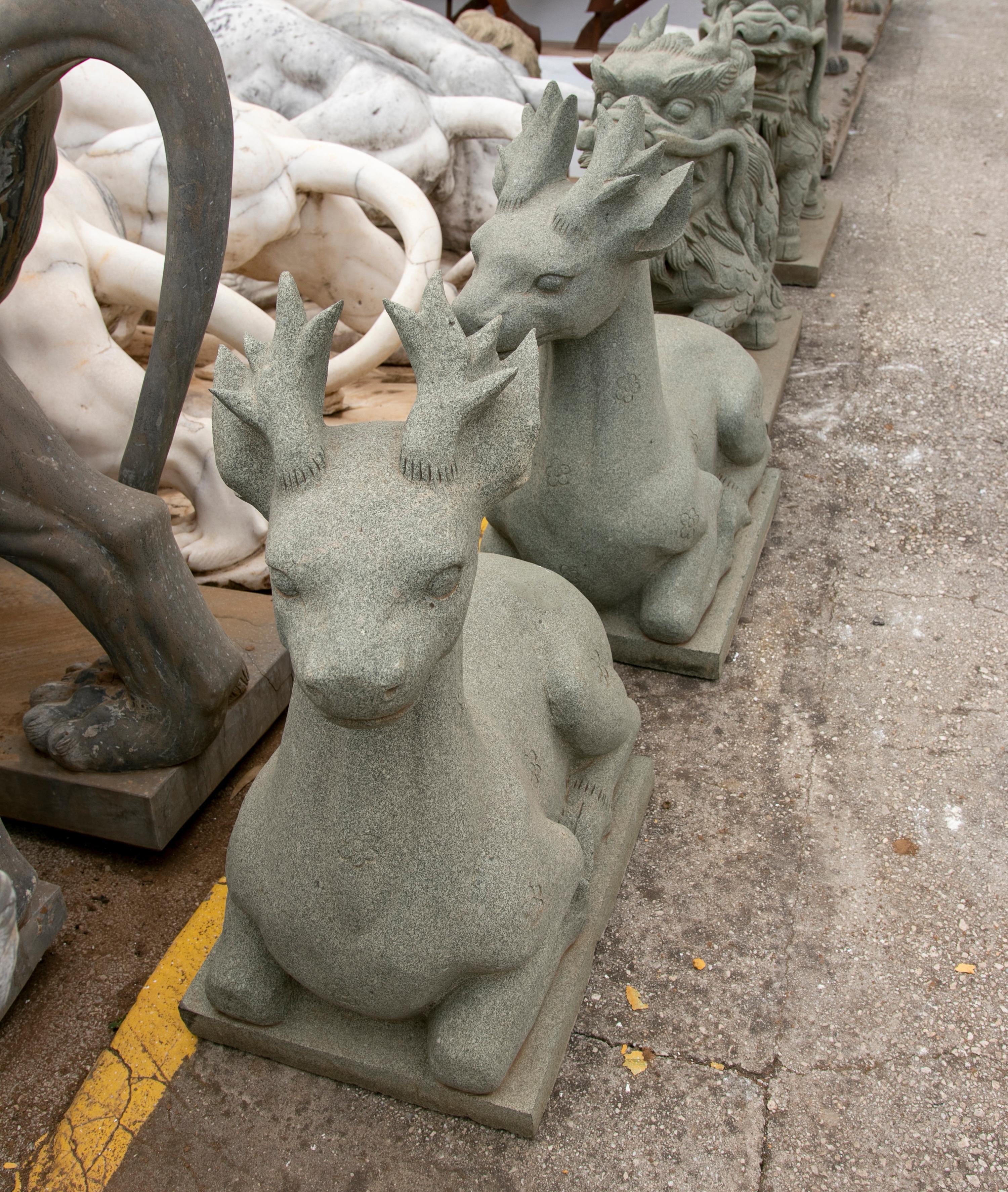 Pair of 1990 hand carved green granite lying deer.