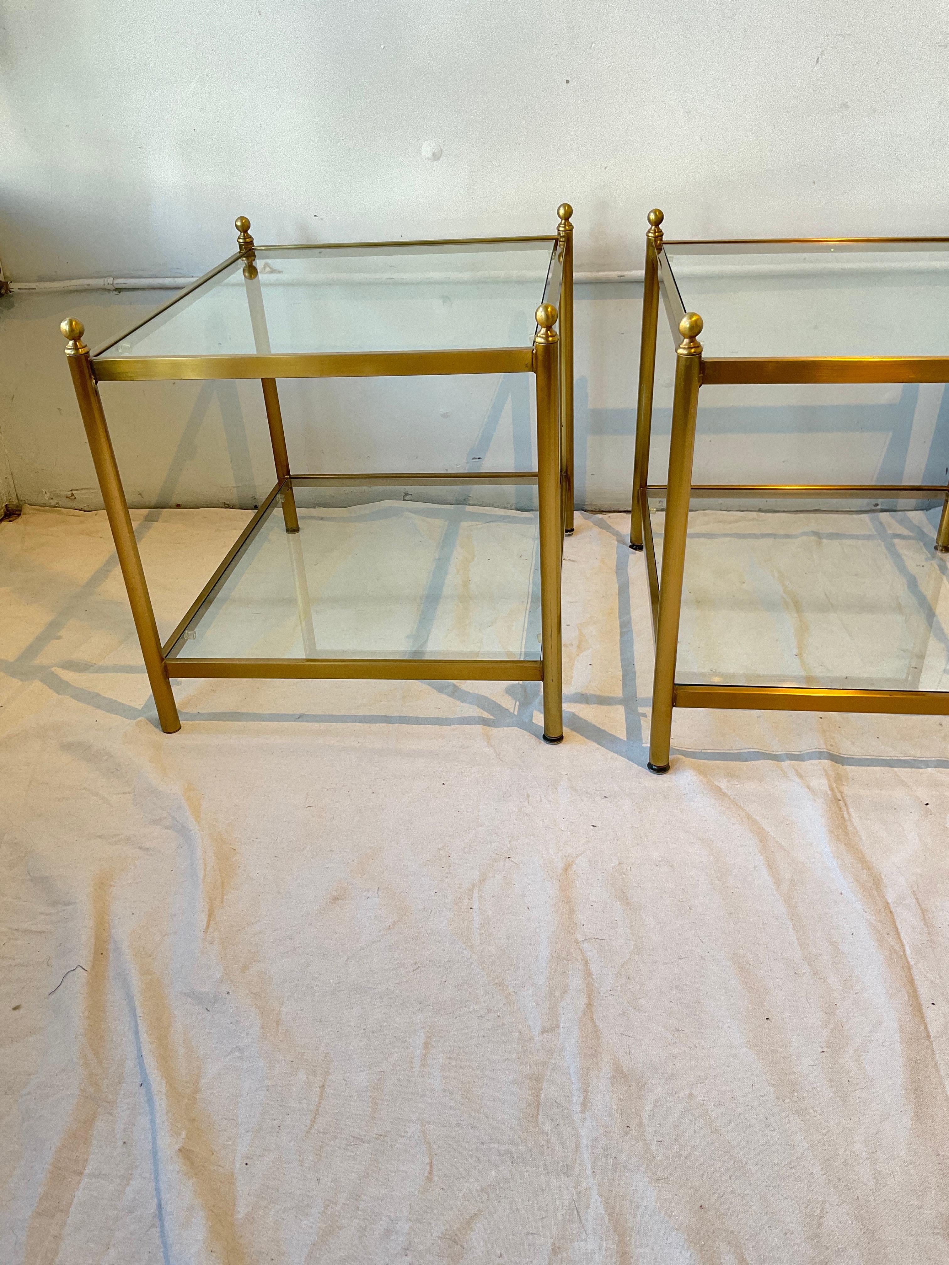 Pair of brass coated two tier side tables. Small chip in one piece of glass as shown in last image.