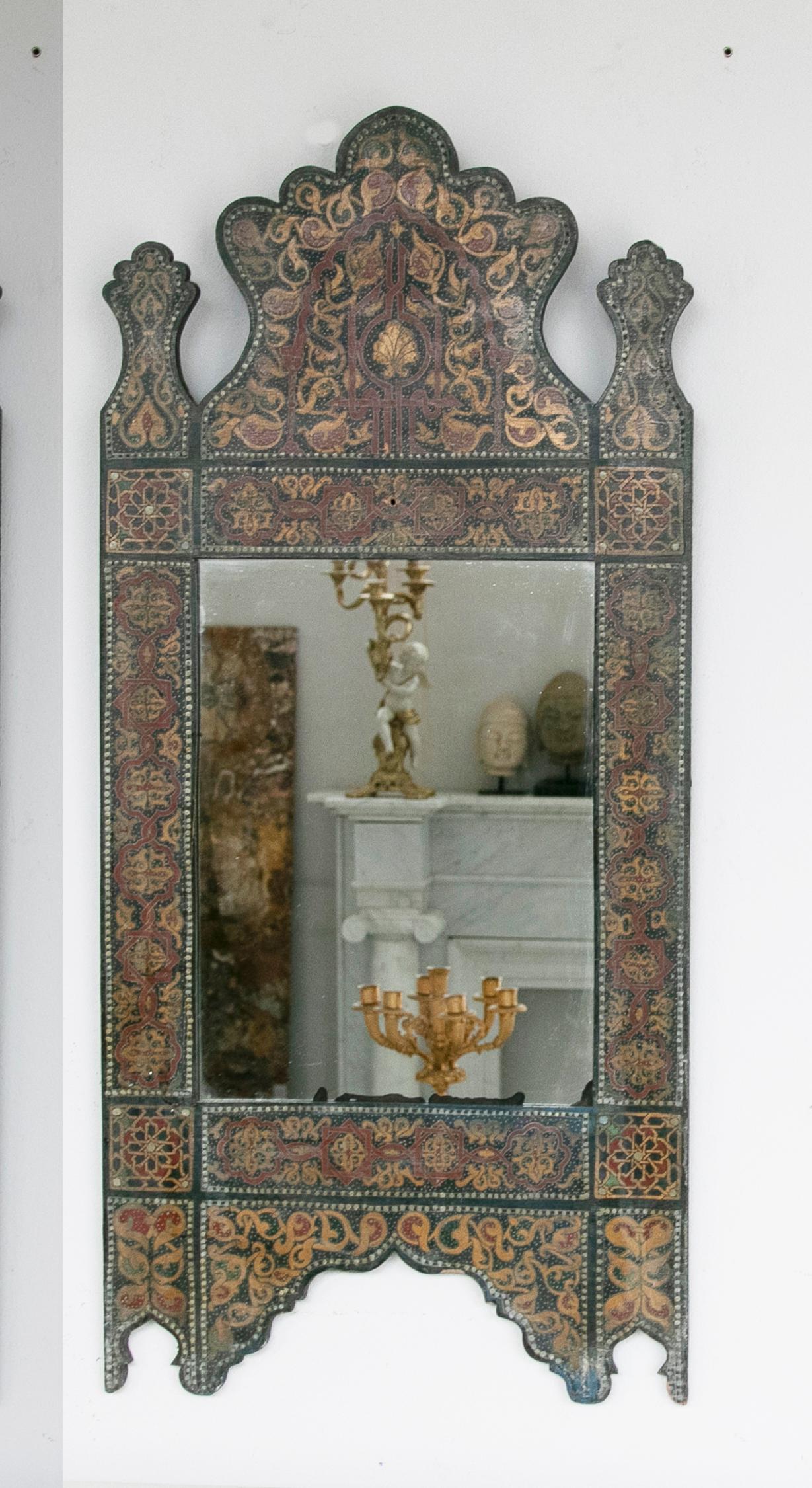 Pair of 1990s Handpainted moroccan style wooden mirror with arabic decorations. It has a reddish patina.