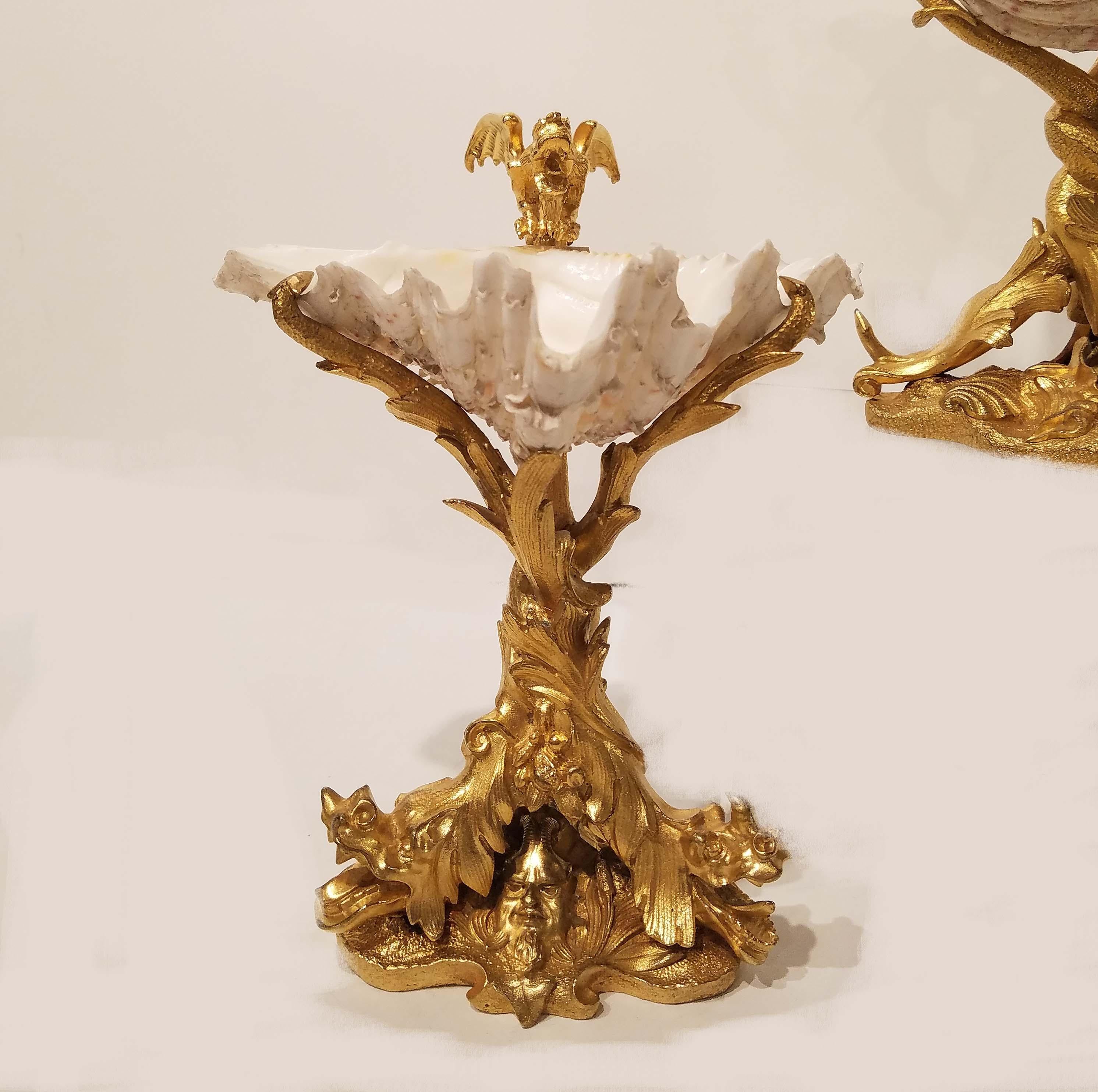 A beautiful pair of gilt bronze and shell grotto tazzas French, circa 1890s.
Decorated with sea dragons and sea elements cast in gilt bronze and with natural shells mounted on top.
   