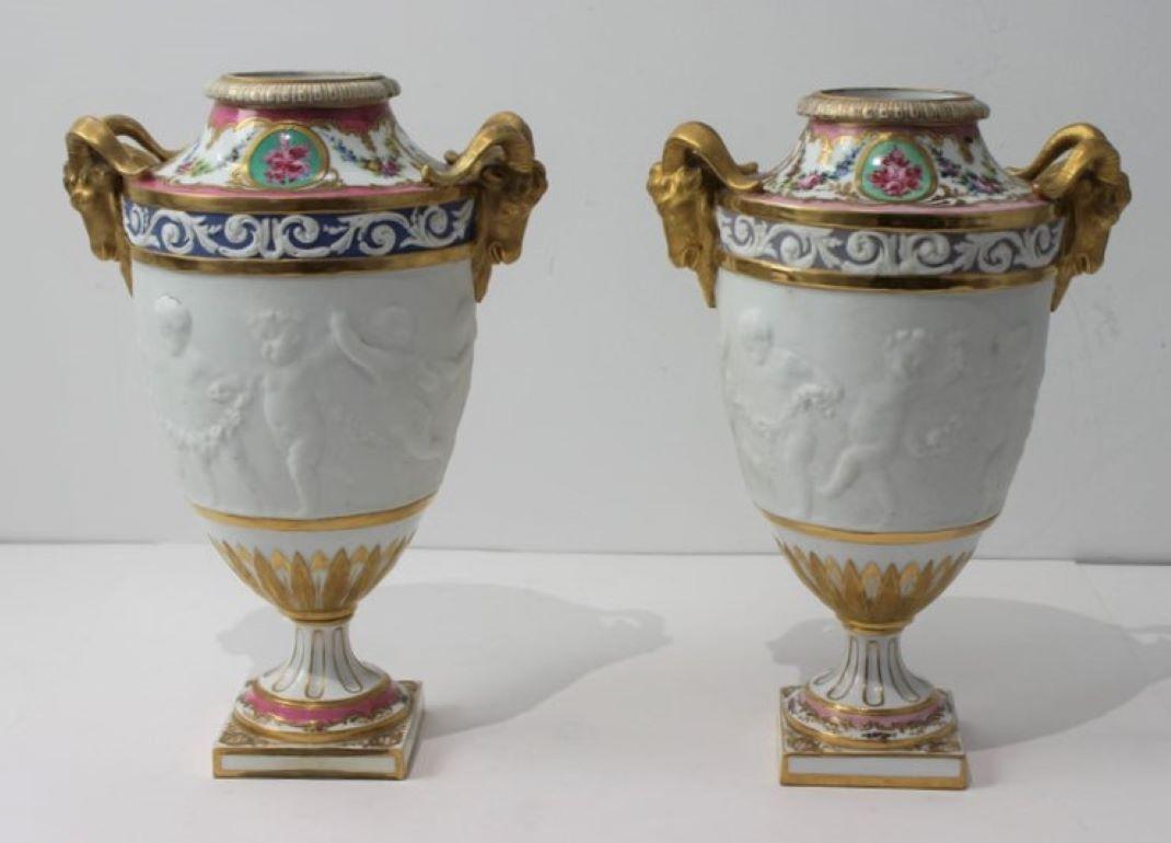 This stylish set of two 19th century Sevres style urns capture the romance of the 18th century with their form, motifs and coloration. 

Note: 
Impressive pair of hand-painted garniture urns, each marked in verso with what appears to be a French